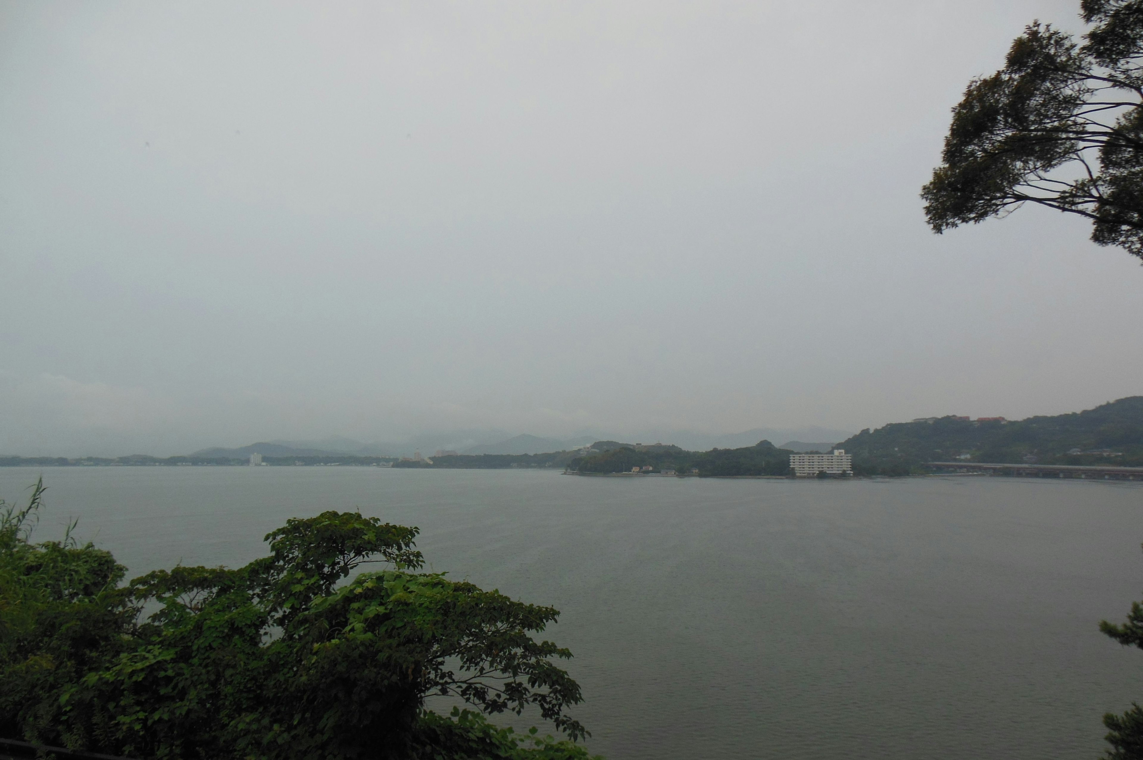 Vista serena del lago con montañas brumosas al fondo