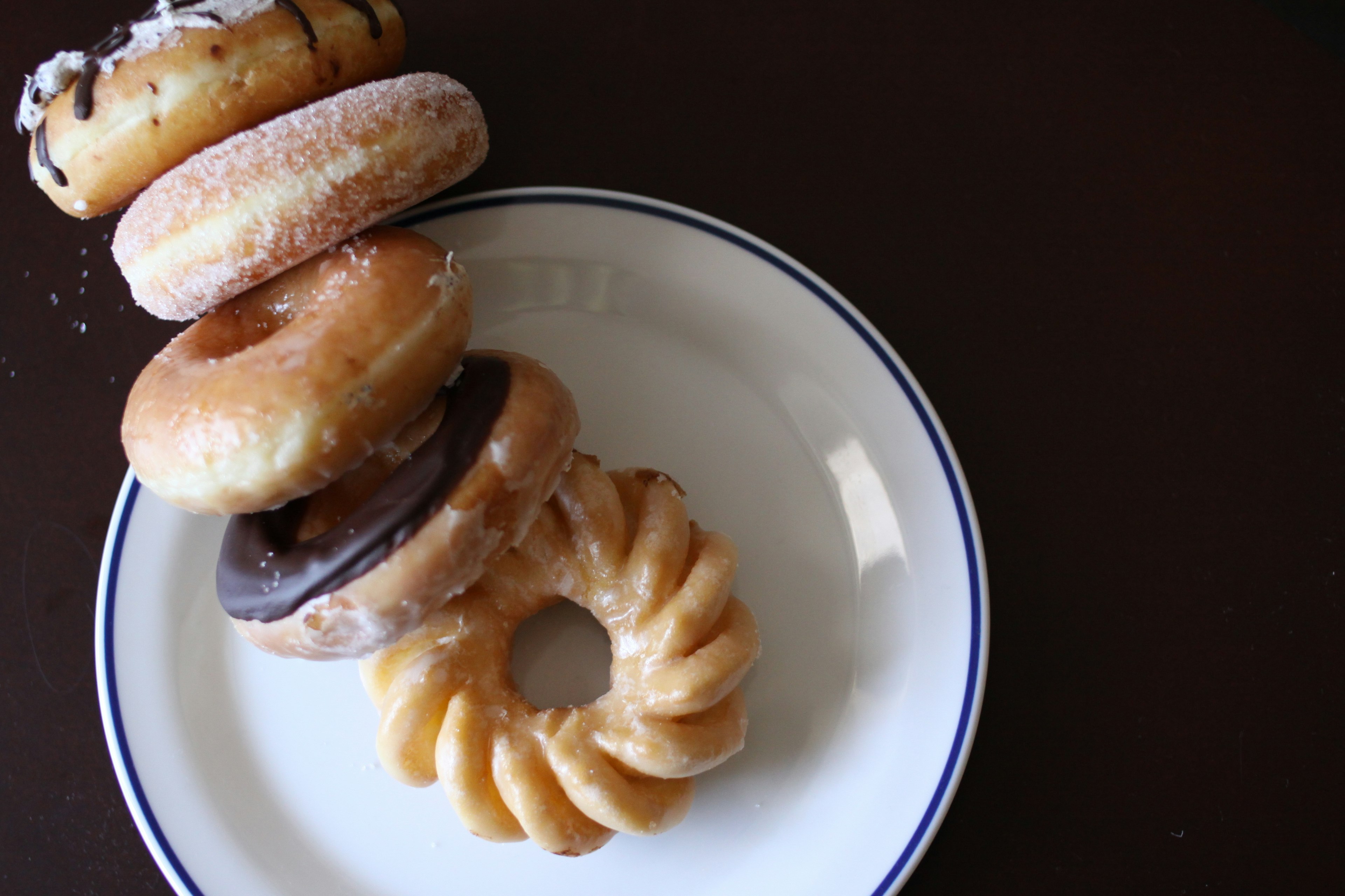 An assortment of five donuts displayed on a plate