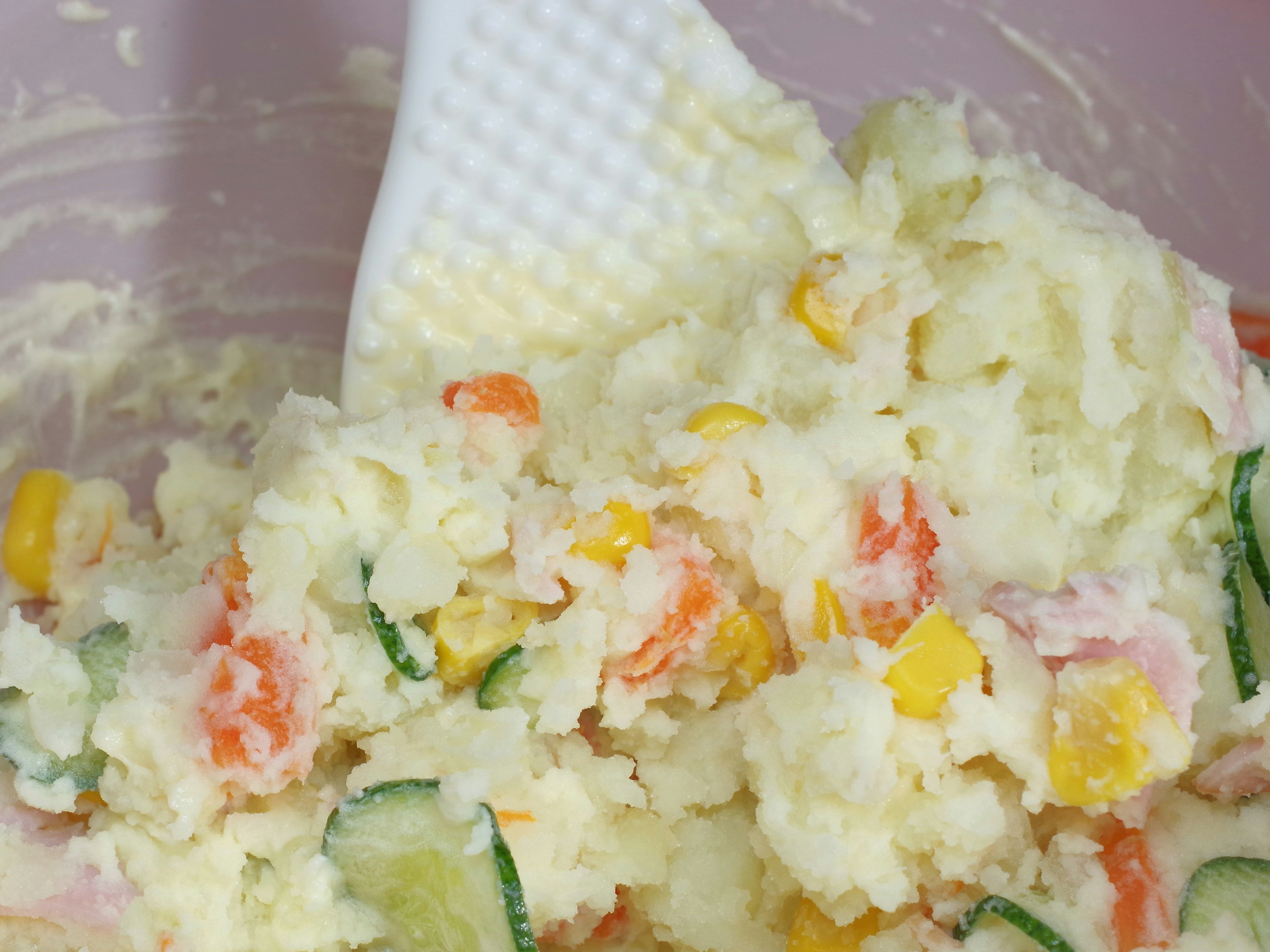 Creamy potato salad mixed with colorful vegetables