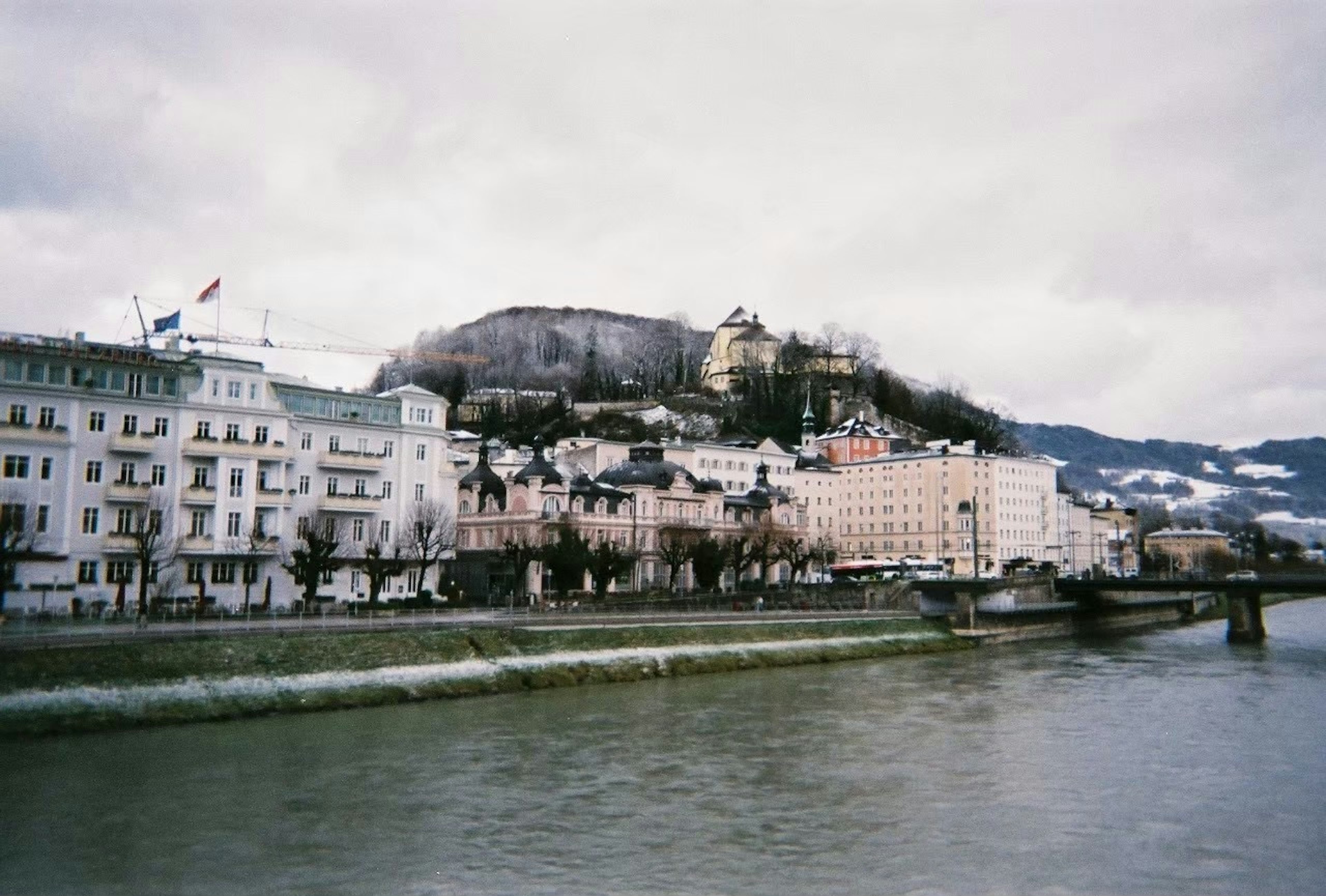 Malersicher Blick auf Gebäude am Fluss und ein Schloss auf einem Hügel