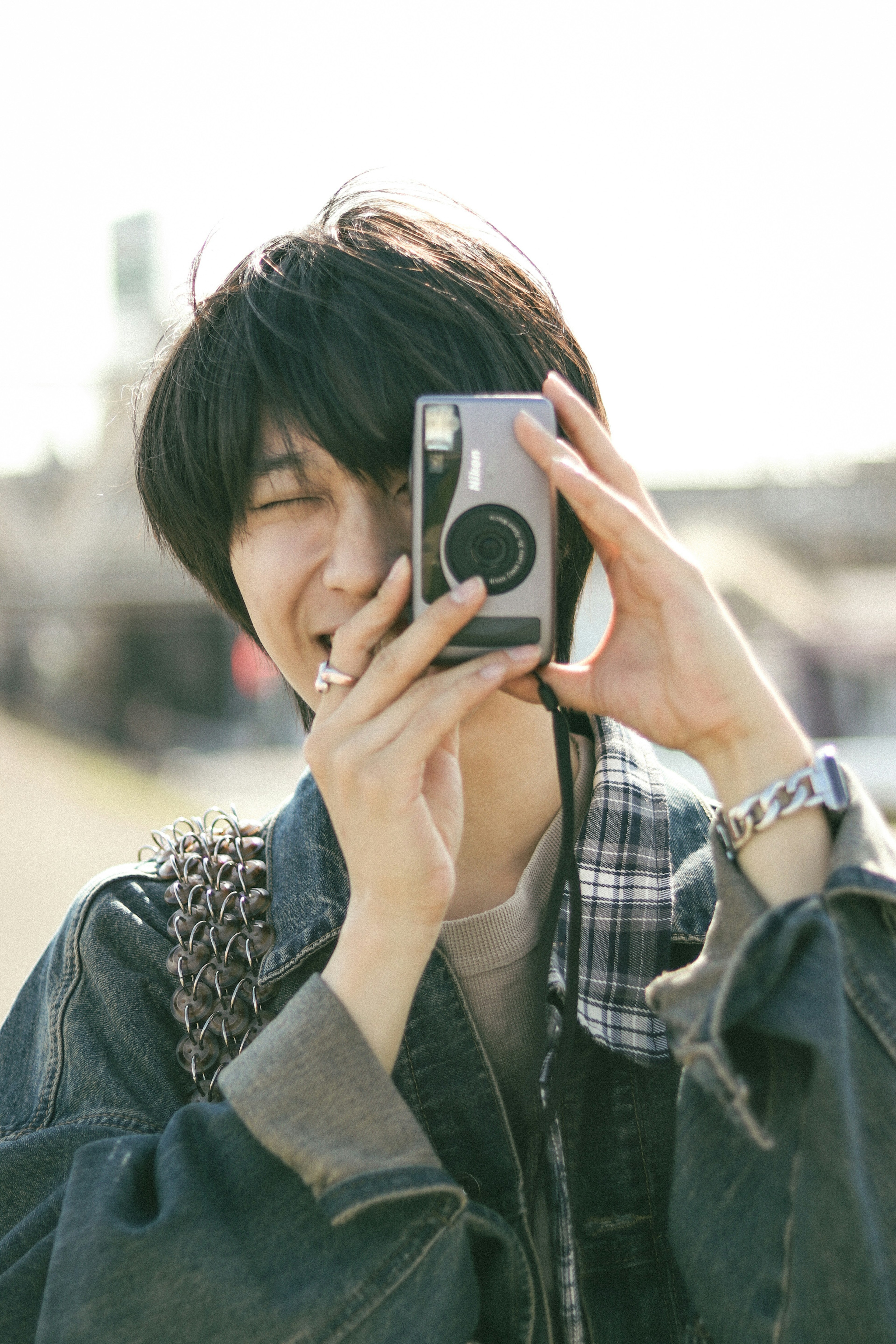 Joven sonriendo y posando con una cámara