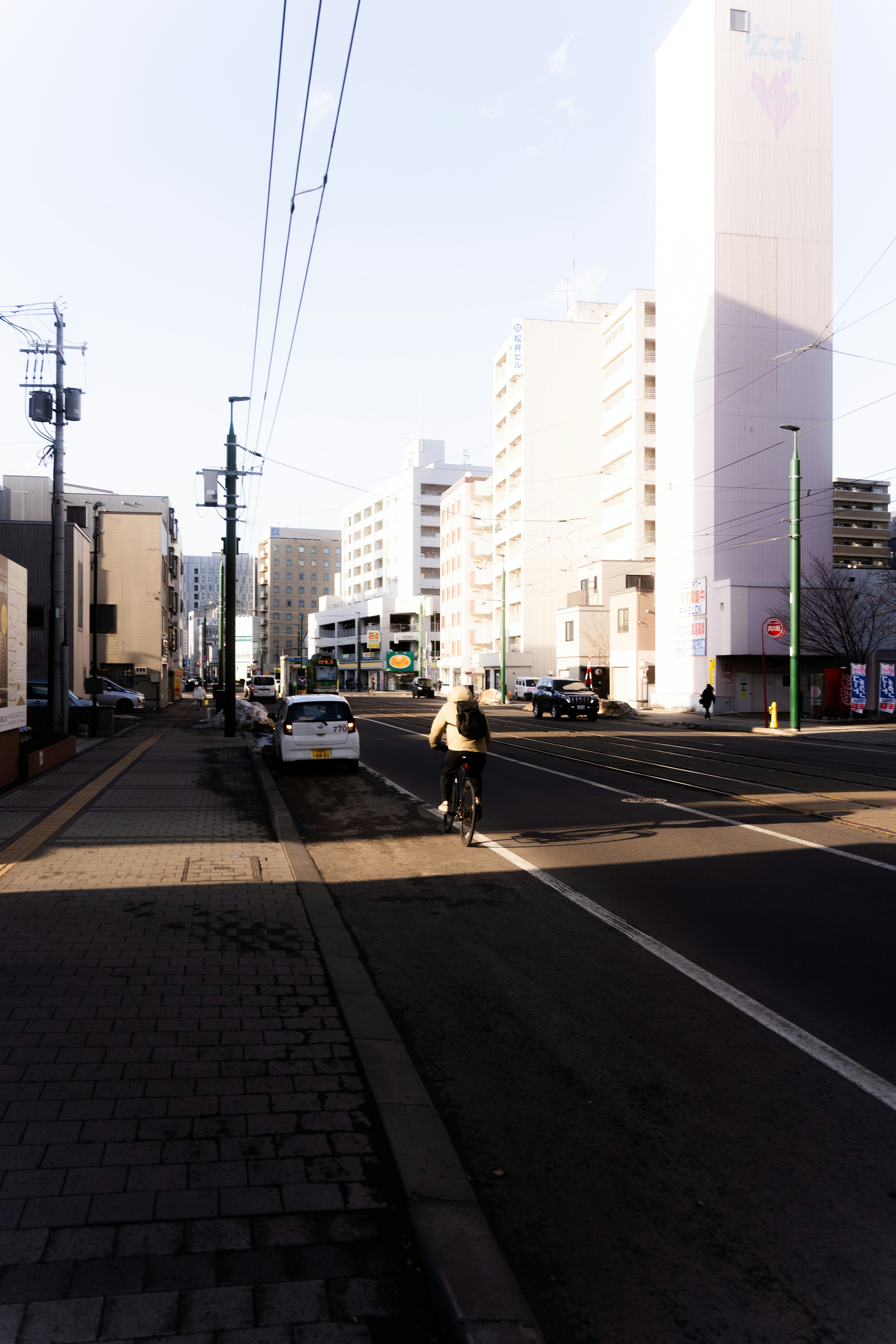 Una persona caminando por una calle urbana con edificios altos