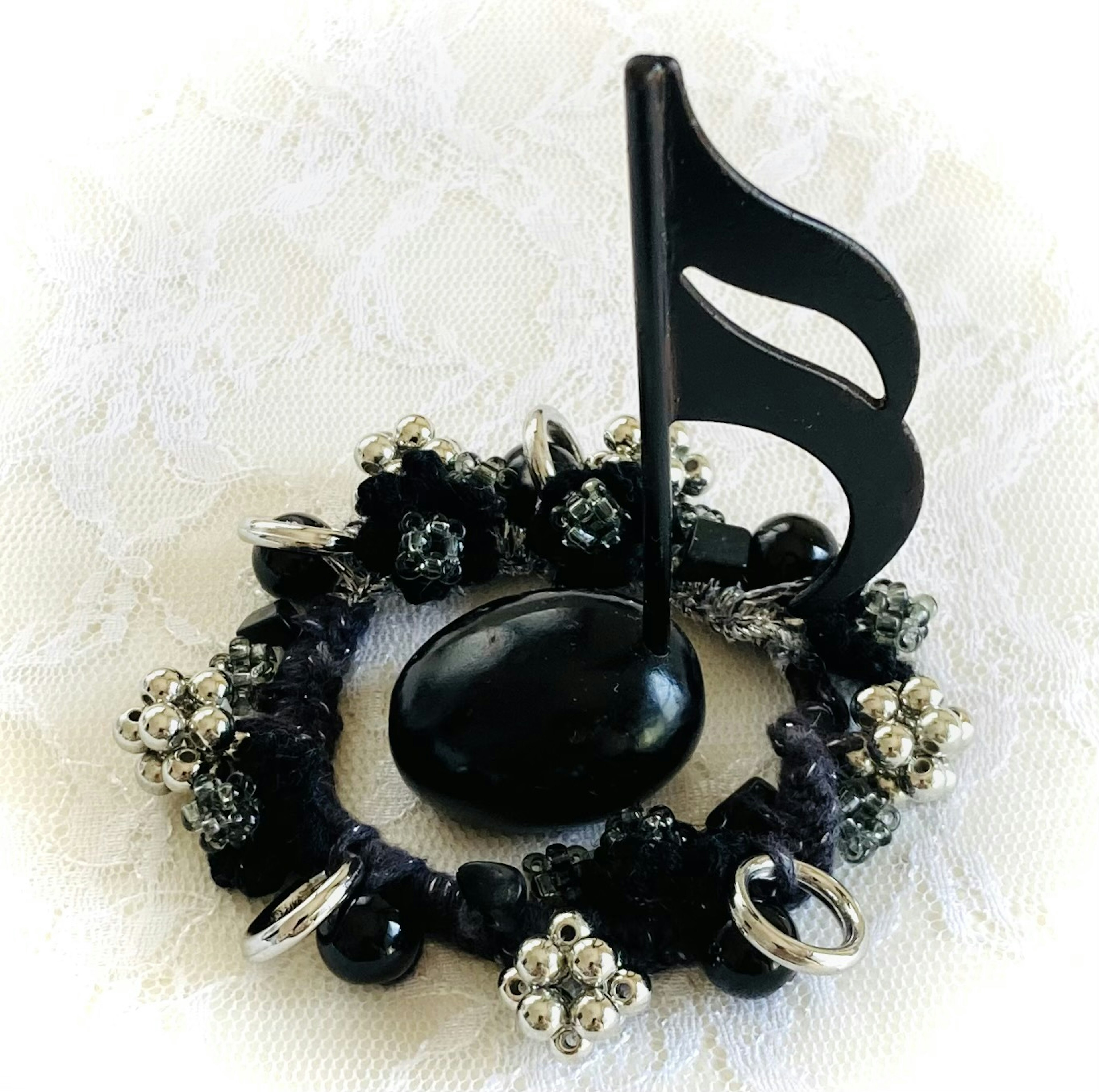 Una base decorativa con una nota musical negra y anillos de gemas