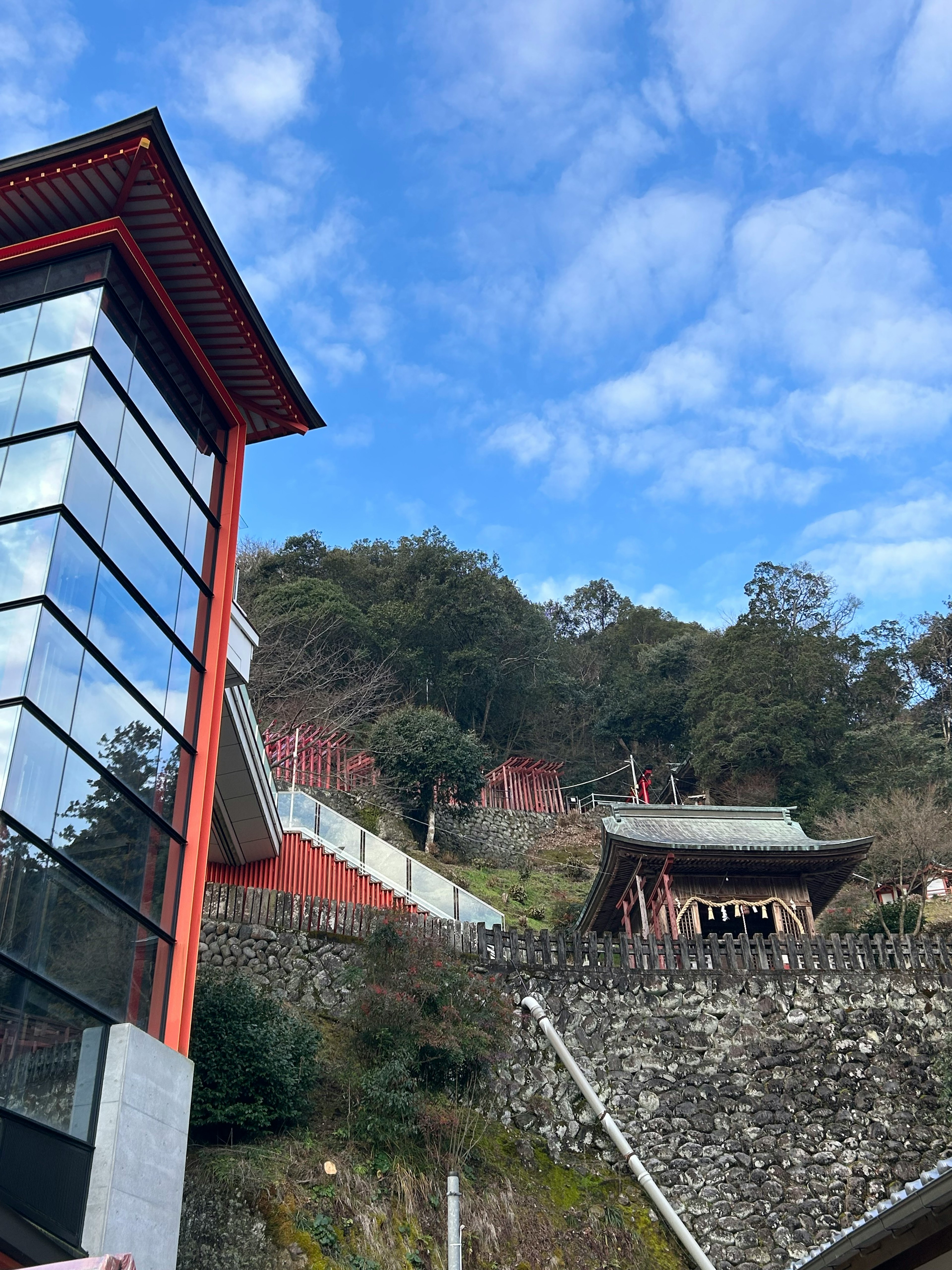 Paisaje con un edificio de techo rojo y un templo en la colina