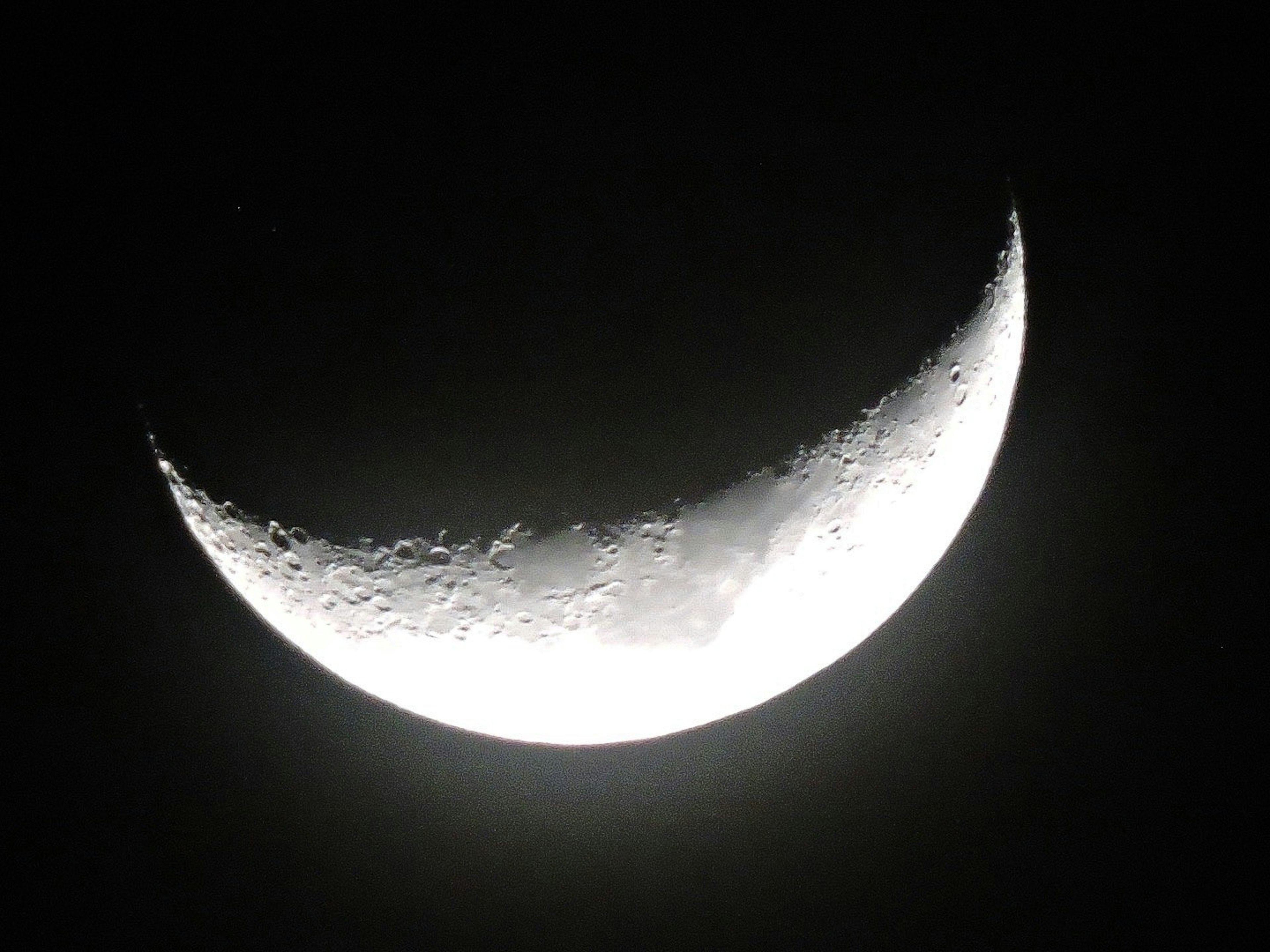 A beautiful image of a thin crescent moon in the night sky