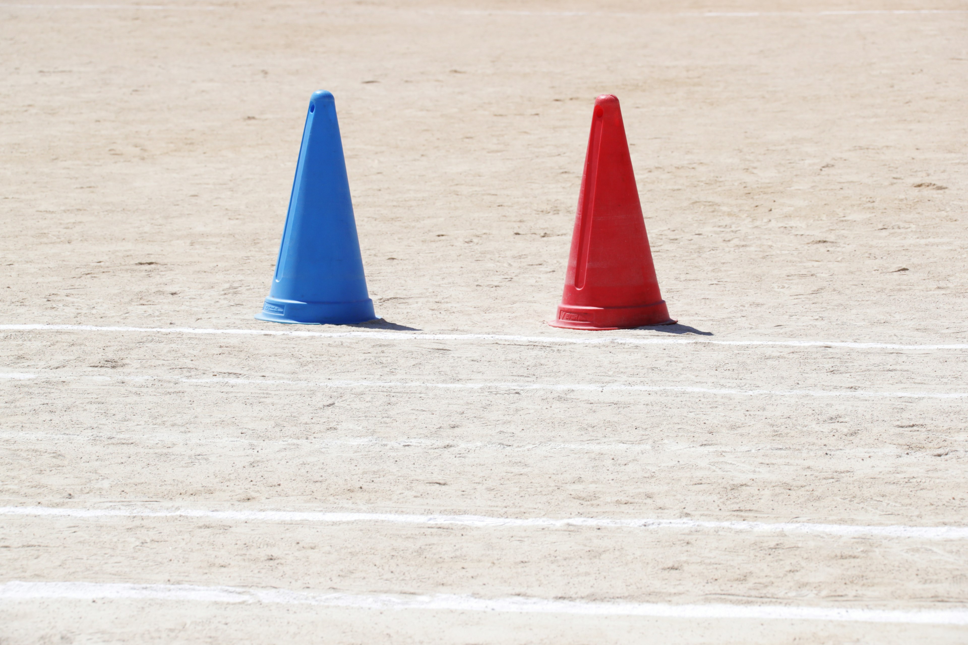 Conos azules y rojos colocados en un campo deportivo