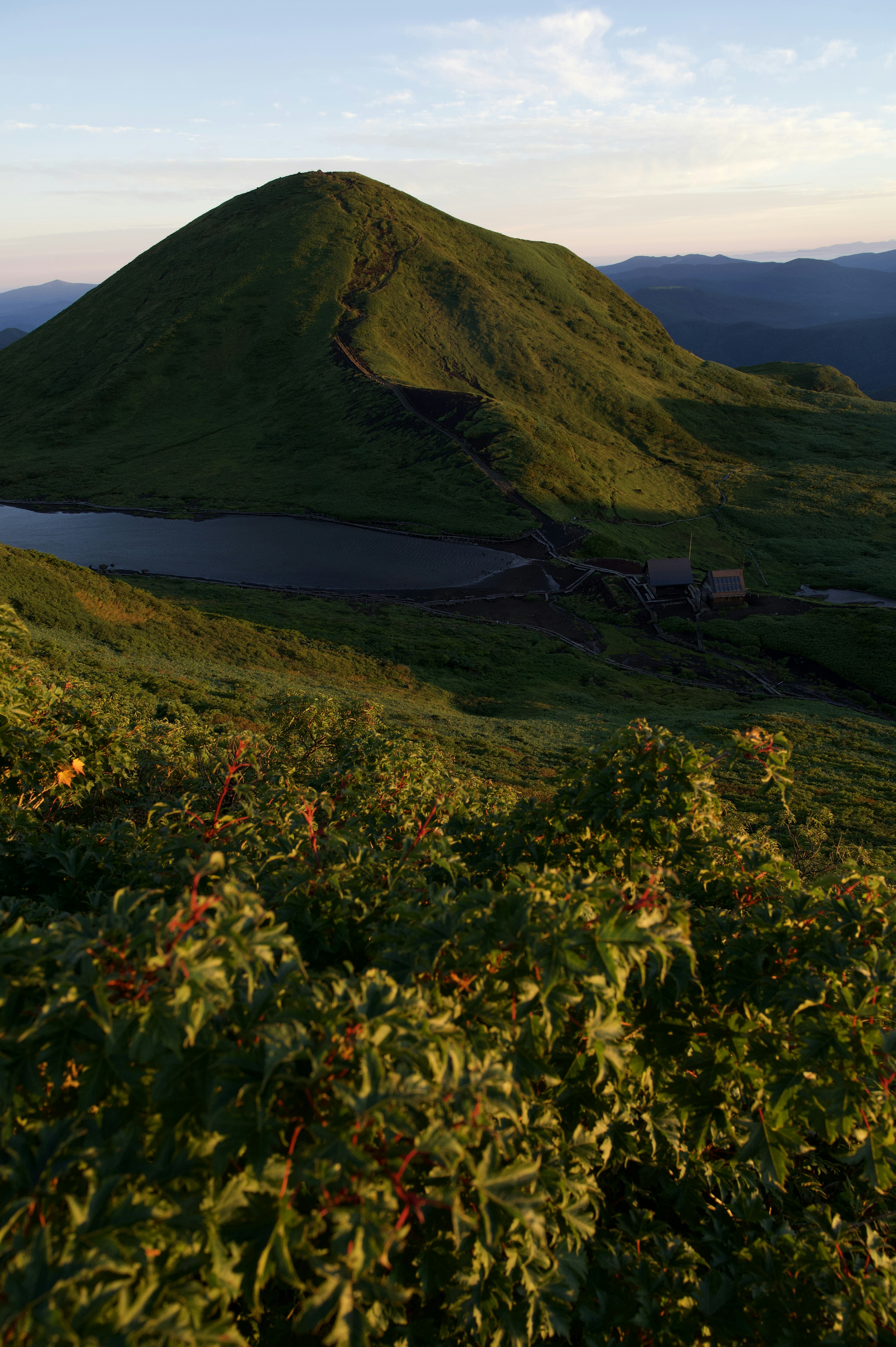 緑の山と湖の風景　青い空と夕日の光