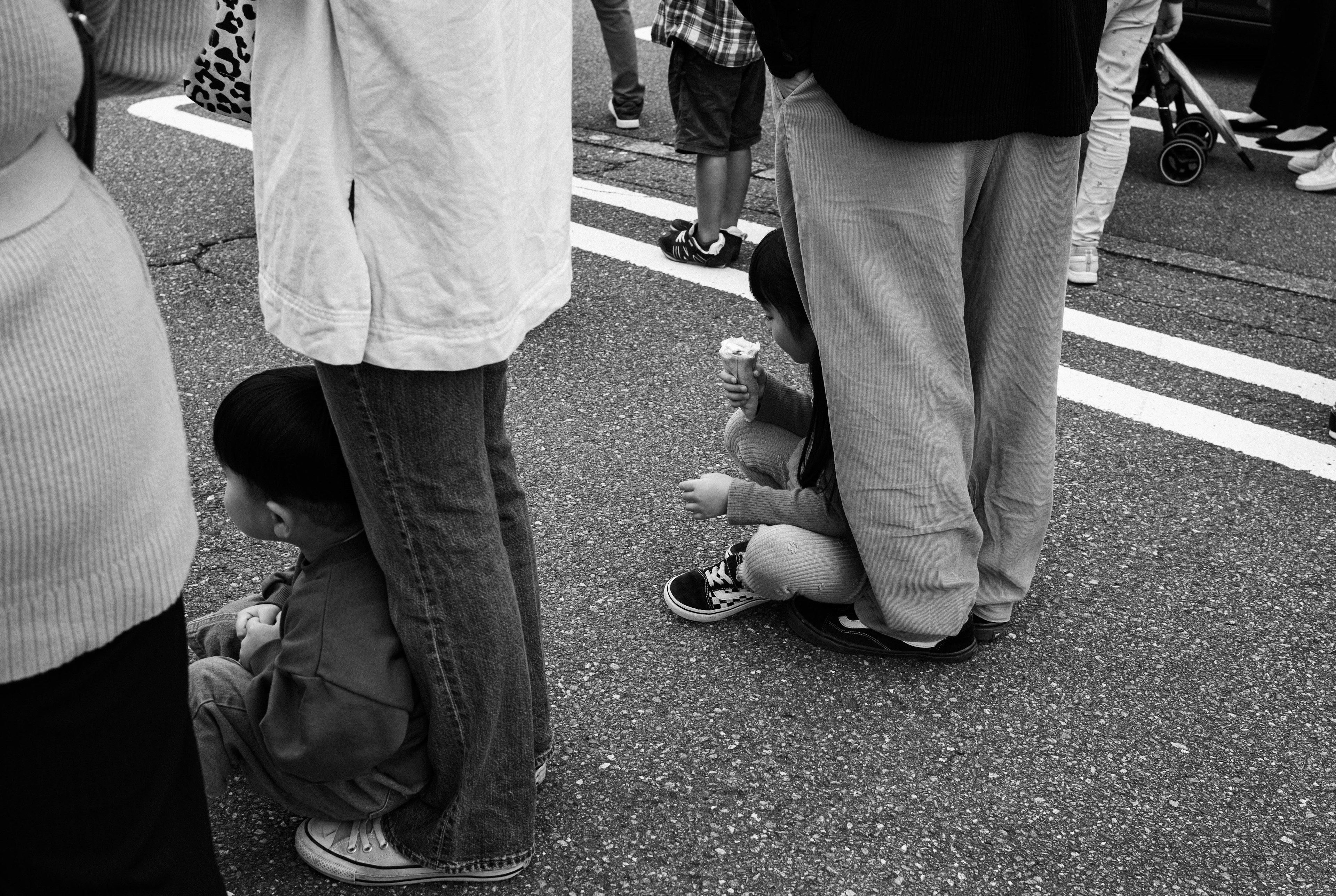 Foto in bianco e nero di bambini che giocano tra la gente