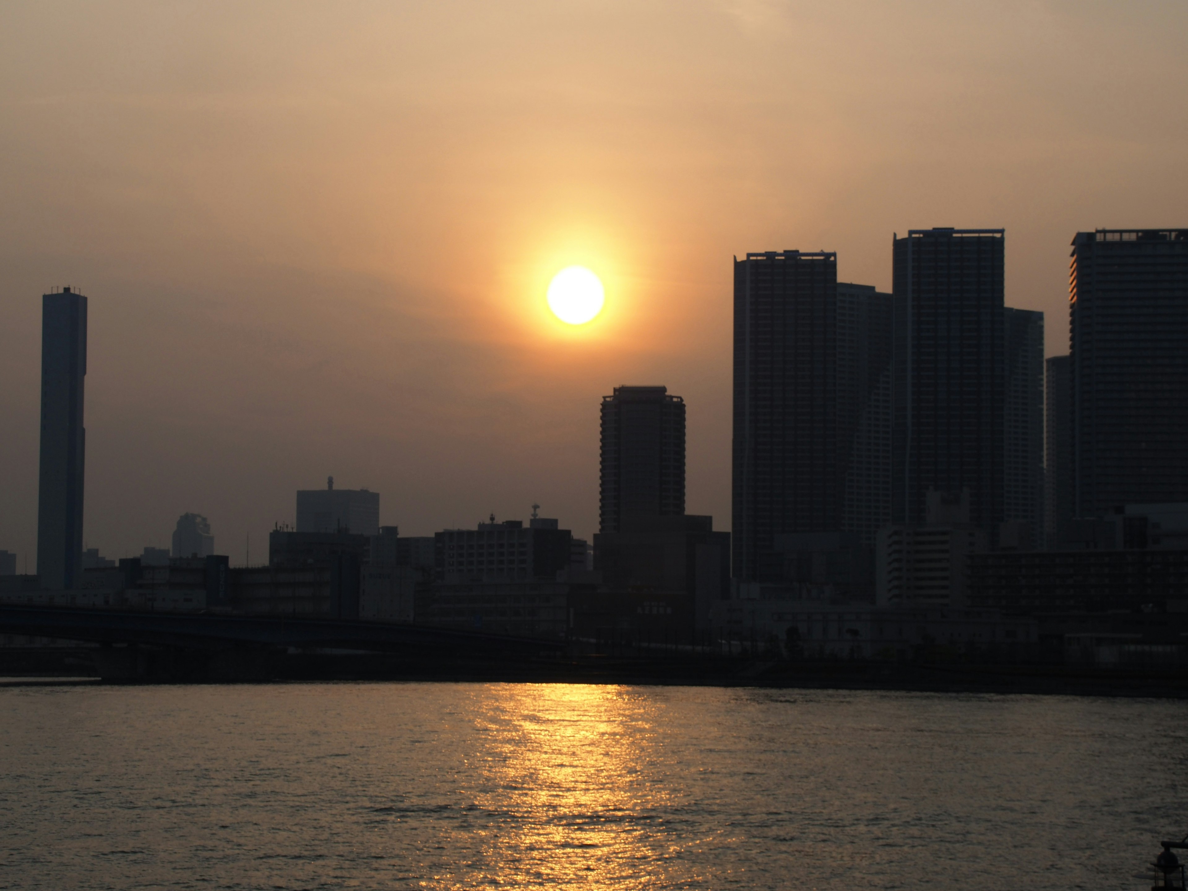 Sunset over a skyline with silhouetted buildings