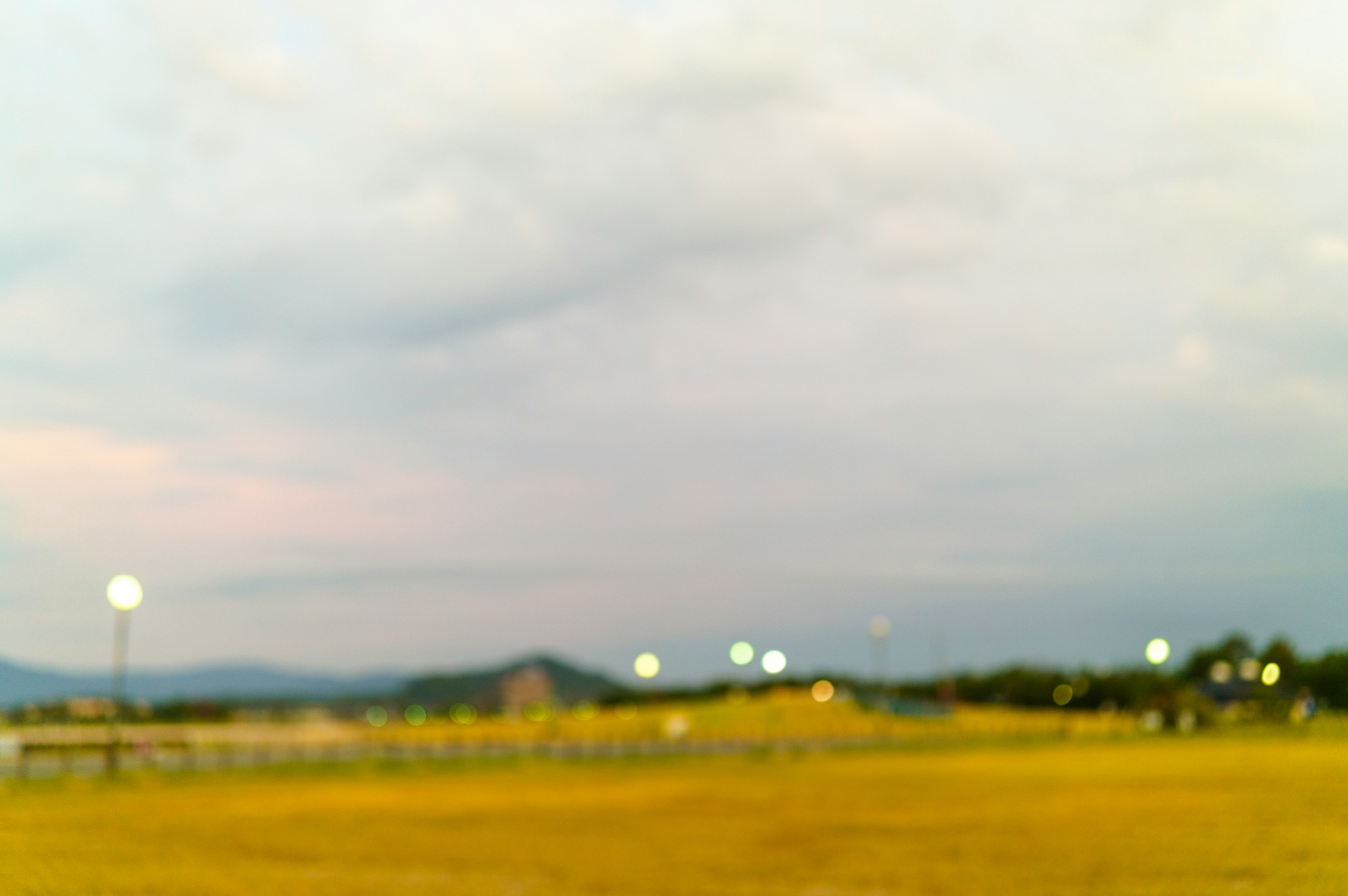 薄暗い夕暮れ時の風景にある明かりと雲