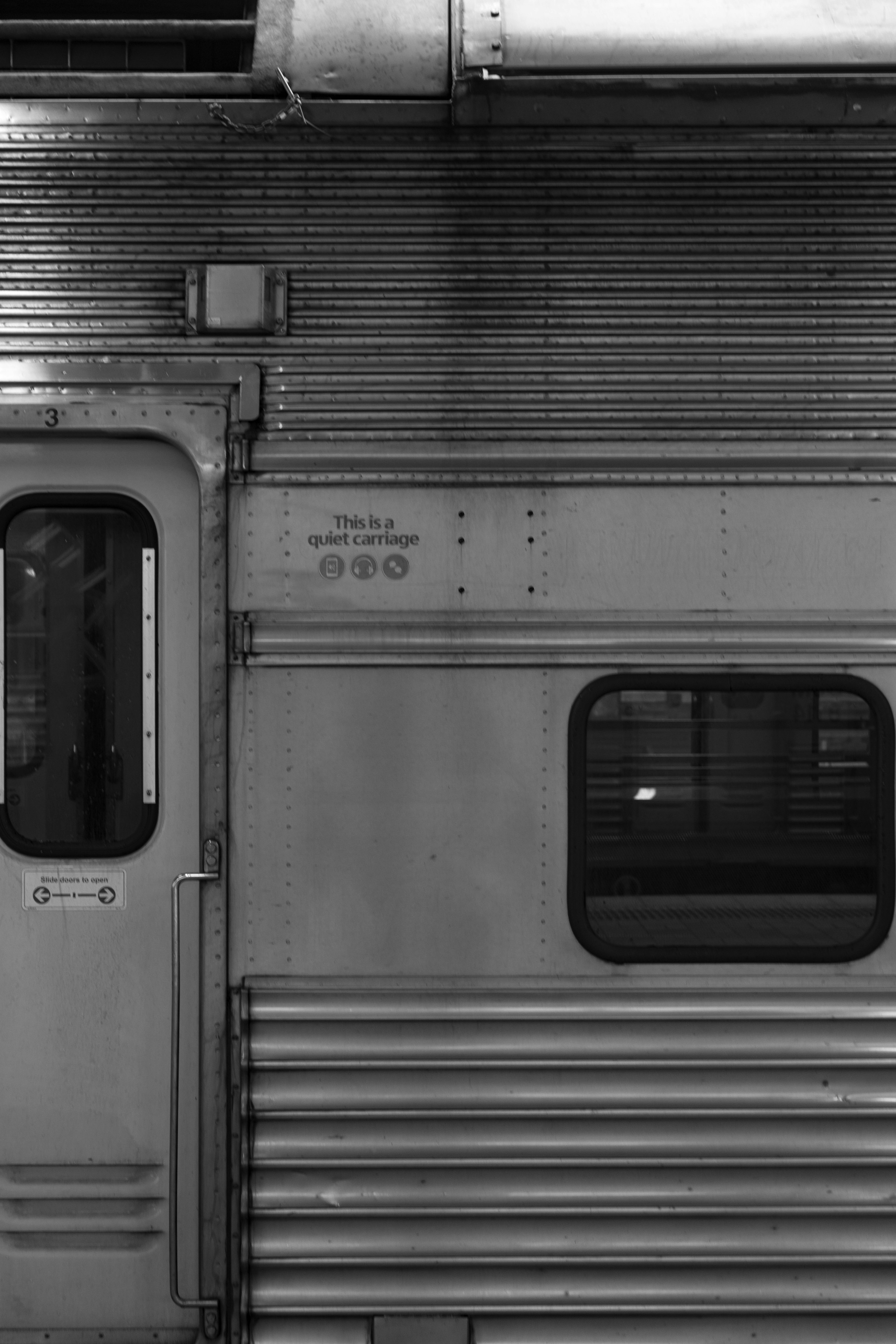 Vista detallada de una puerta y una ventana de un vagón de tren en blanco y negro