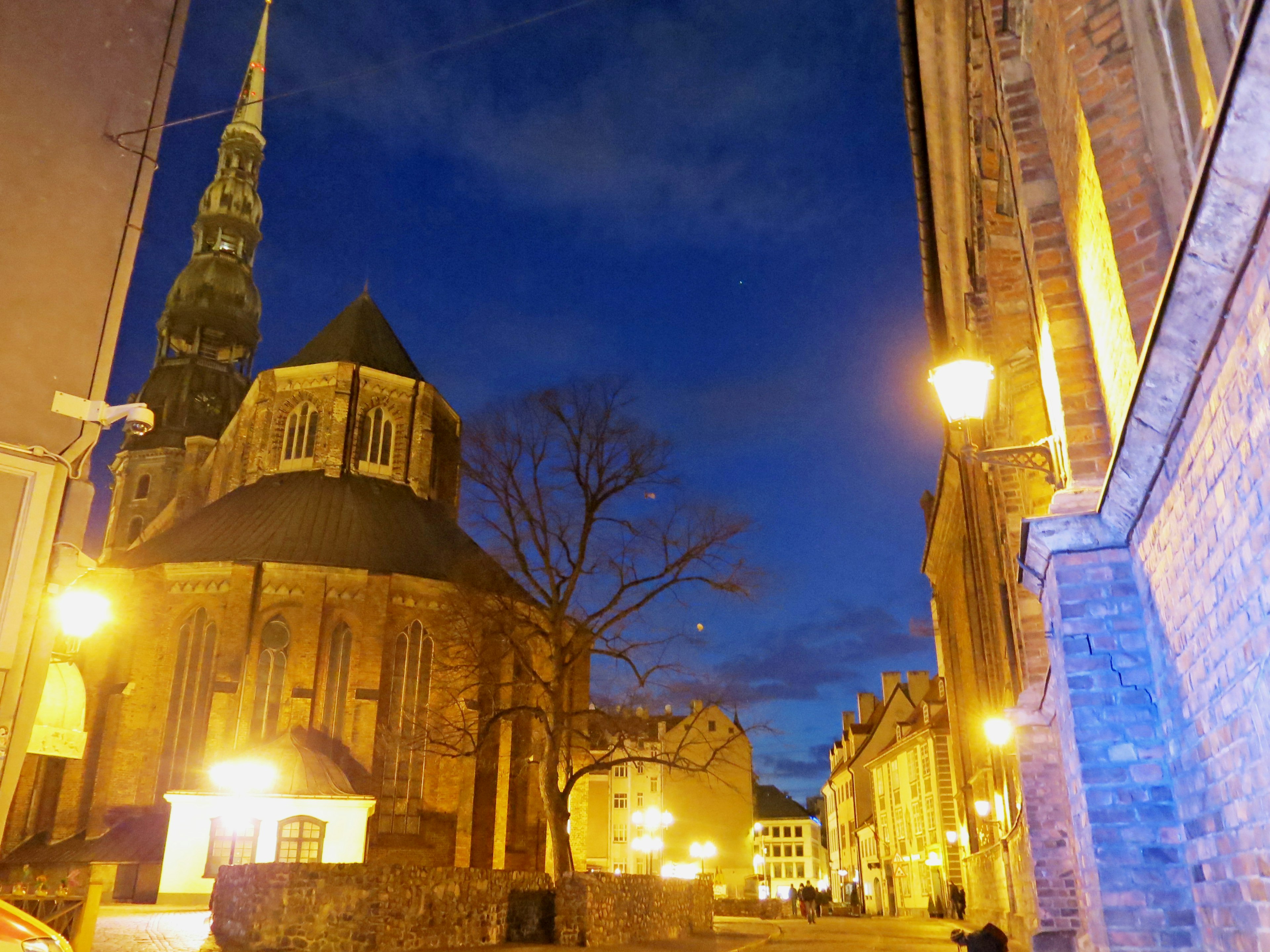 Iglesia iluminada por la noche con luces de la ciudad circundante