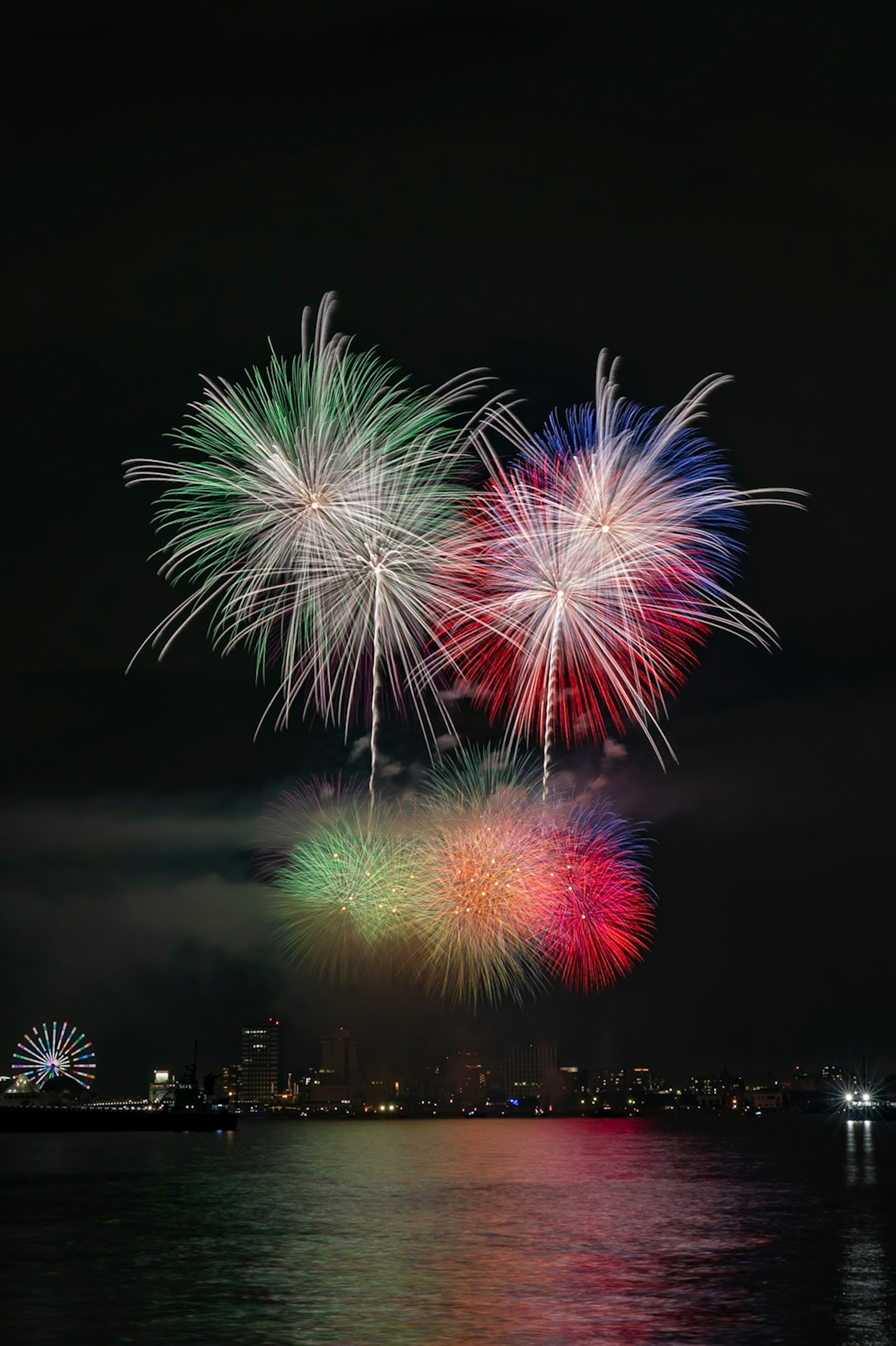 Fuochi d'artificio colorati che esplodono nel cielo notturno su uno skyline cittadino