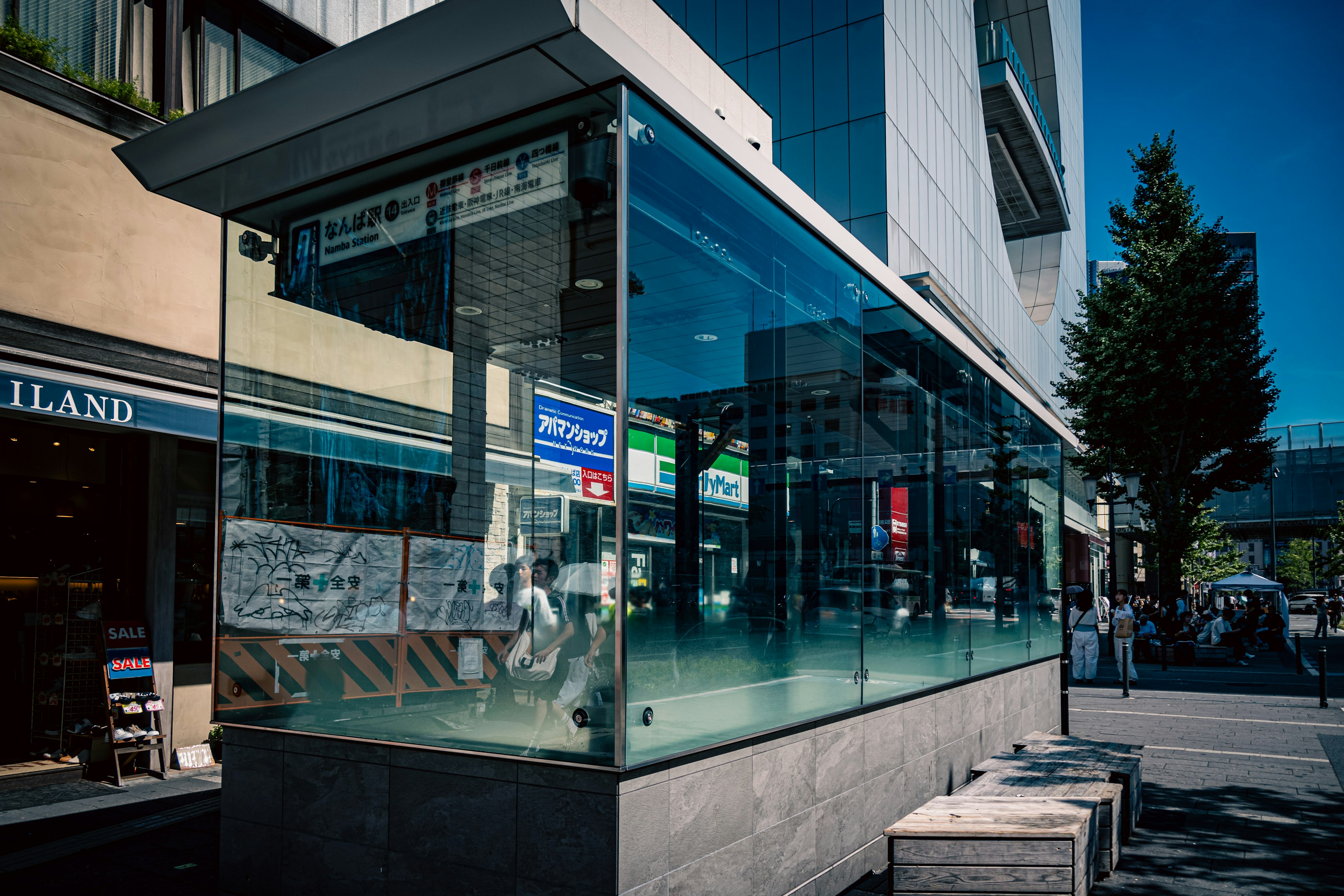 Glass bus stop with nearby building facade