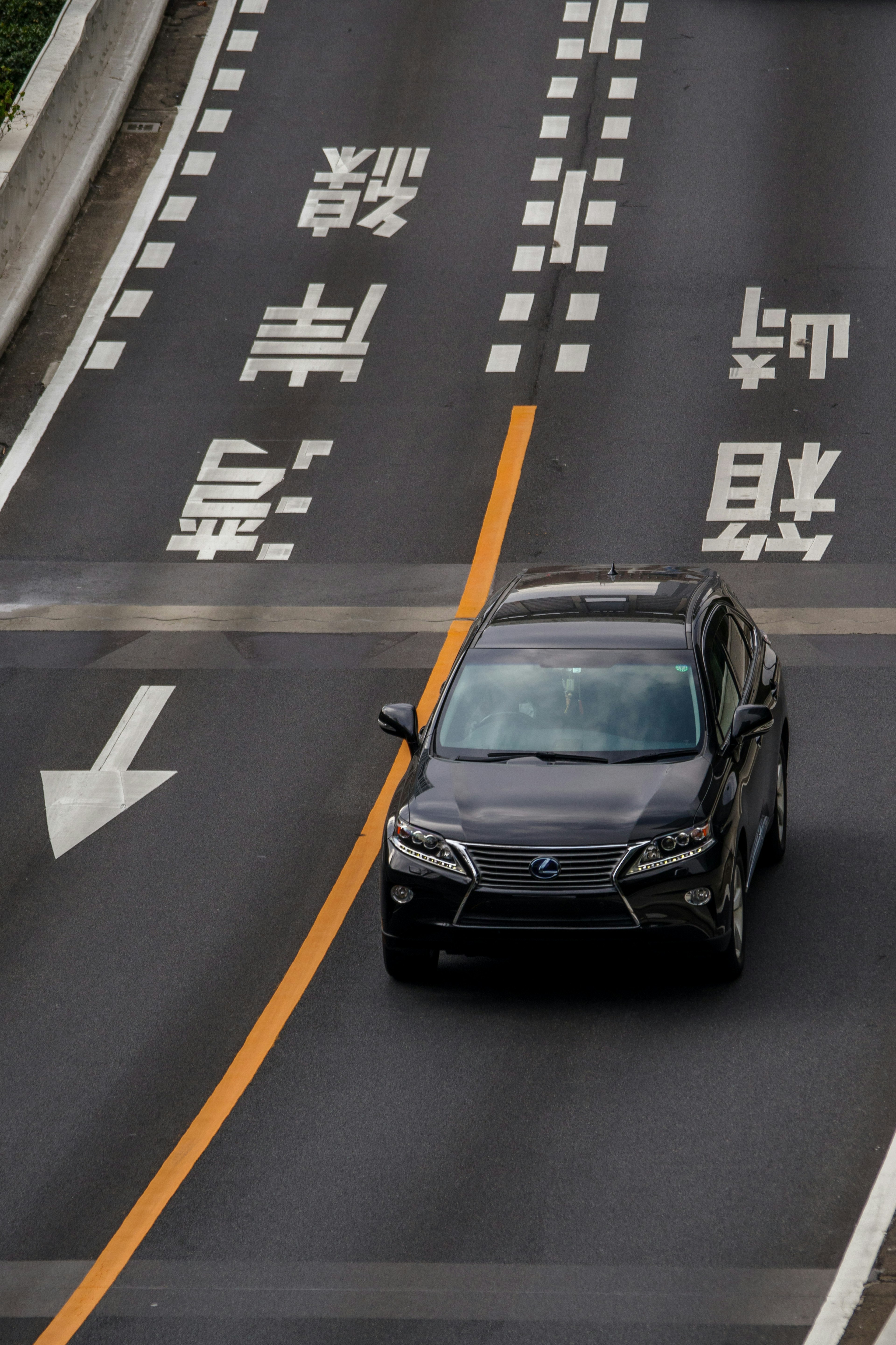 黒いSUVが道路を走っている 交通標識が見える