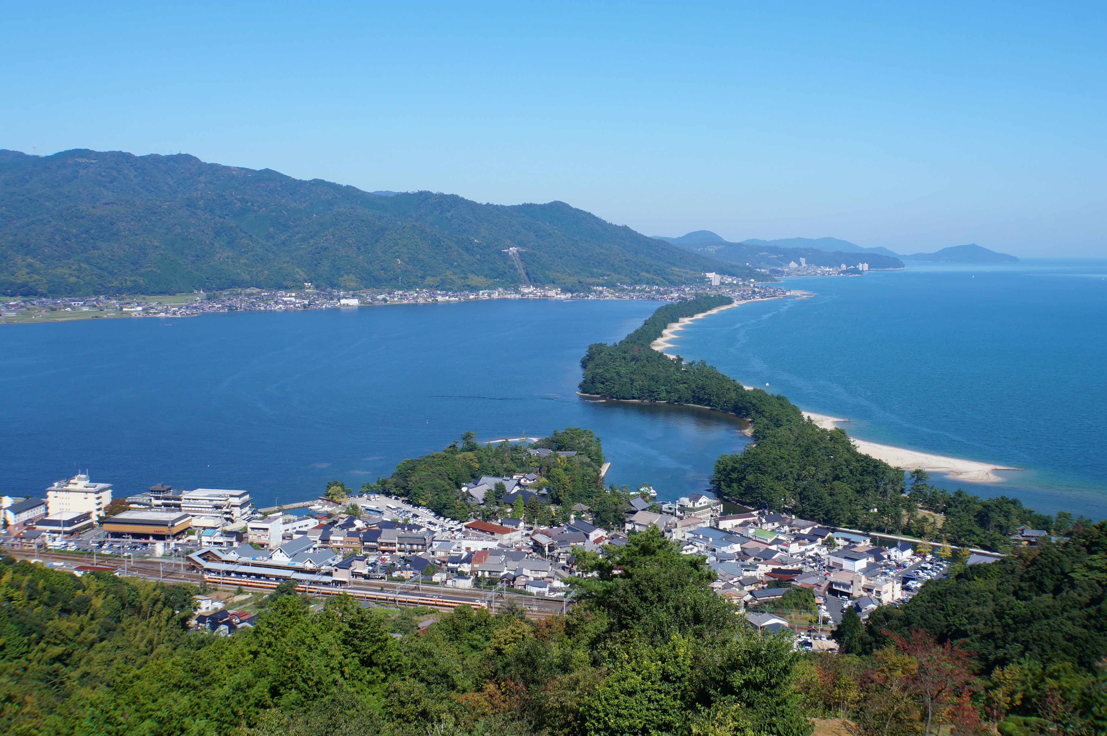 A scenic view of a coastal town and ocean from a hillside