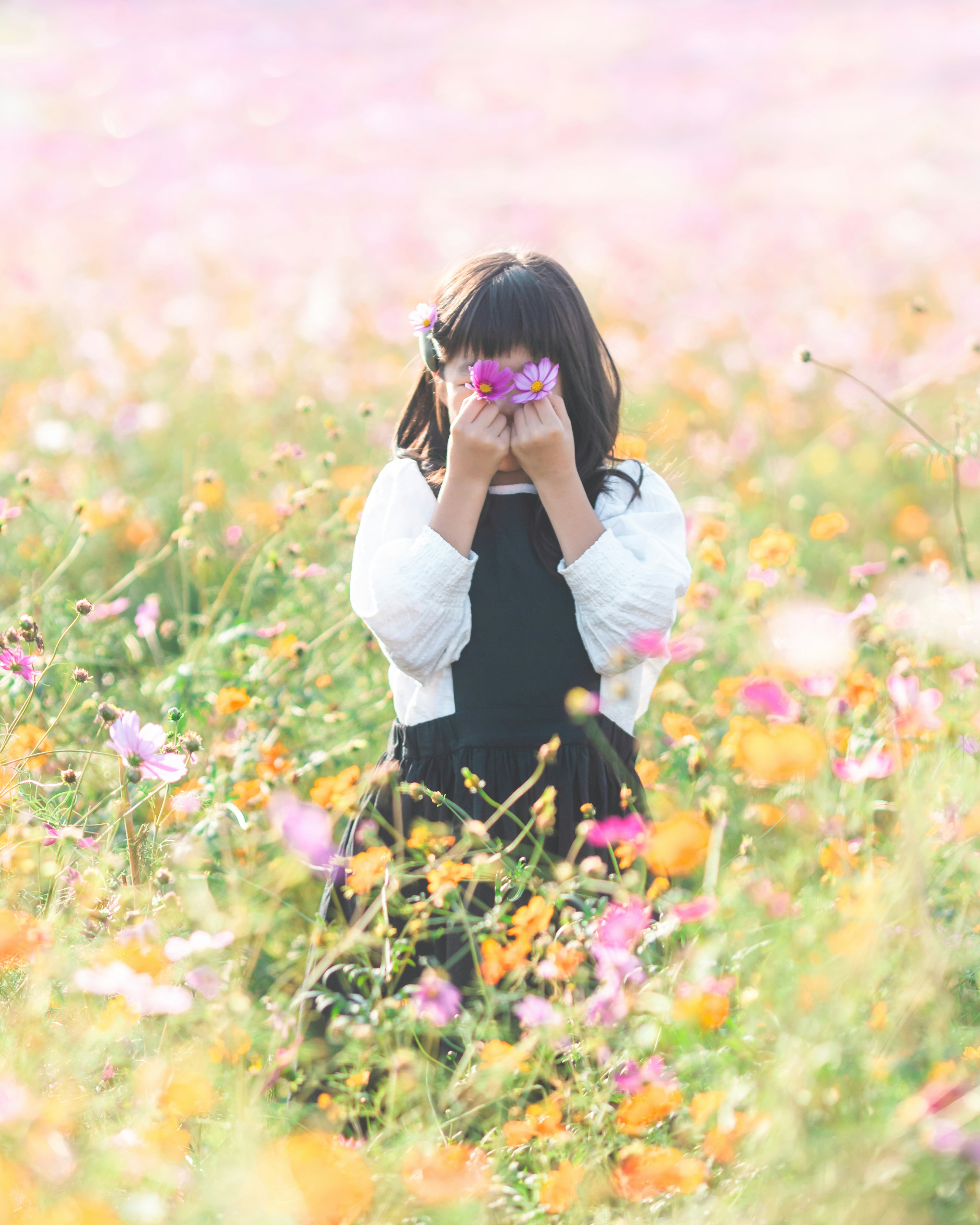 Seorang gadis memegang bunga di ladang bunga berwarna-warni