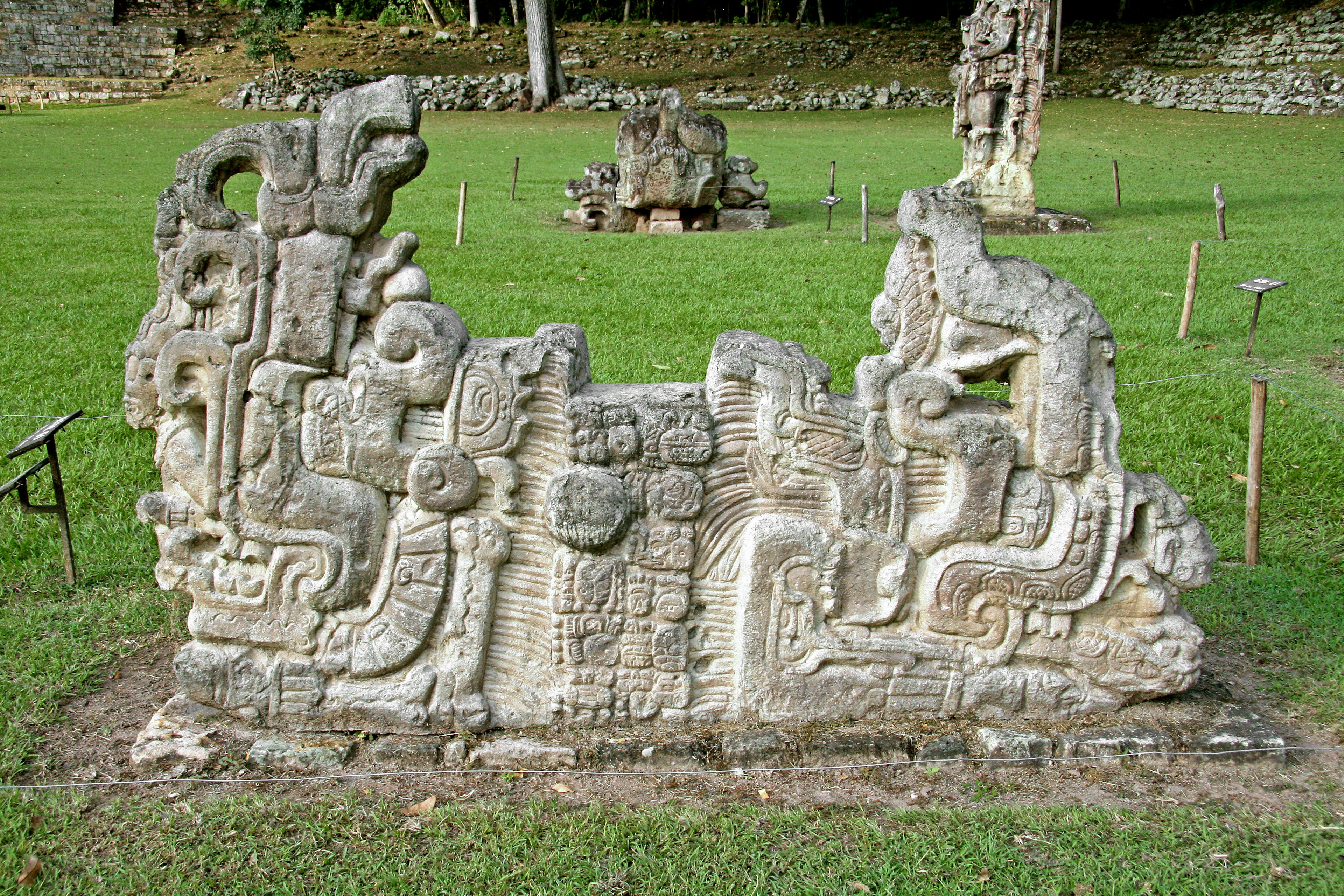 Sculptures mayas anciennes dans un site archéologique herbeux