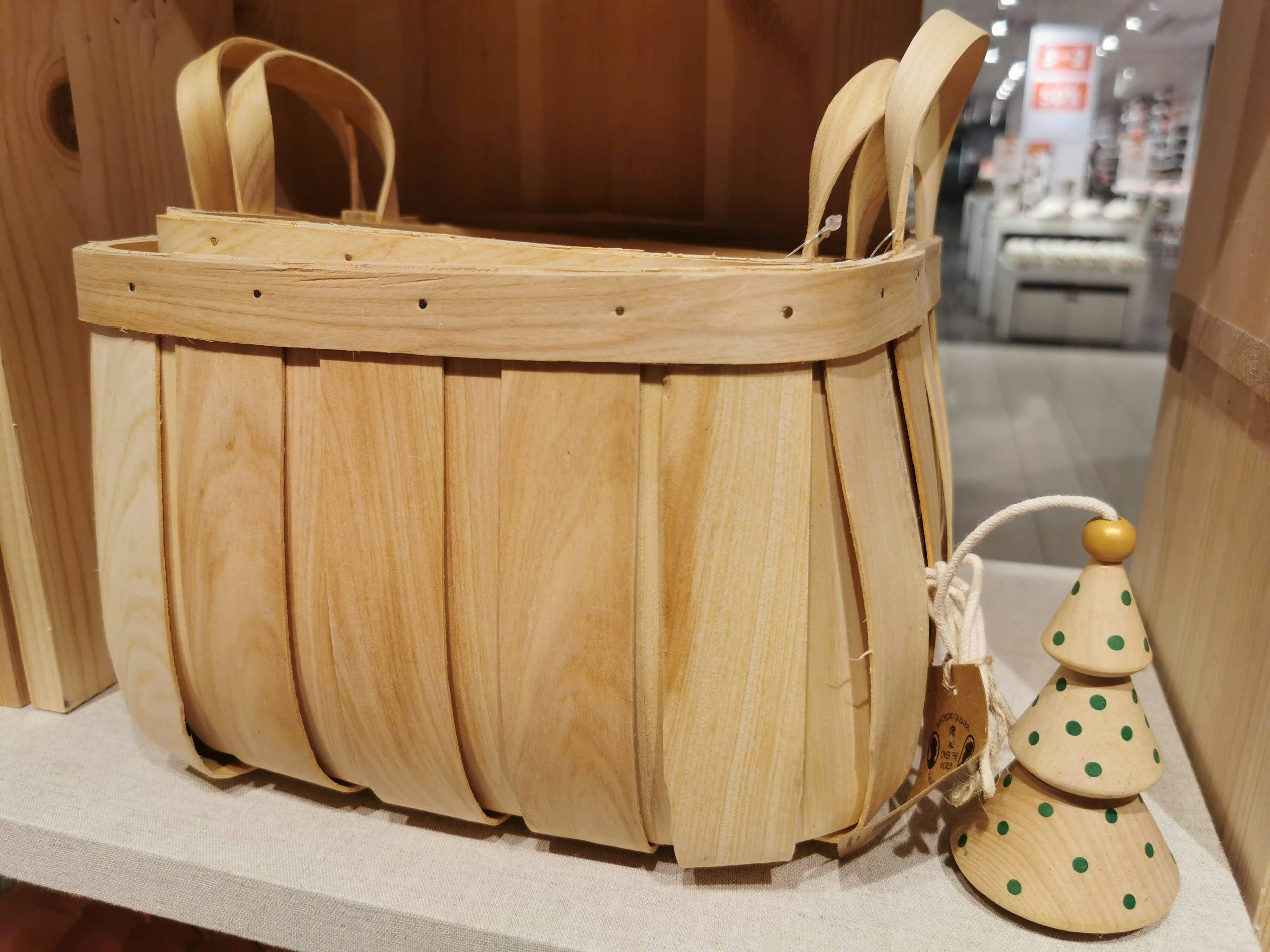 Cesta de madera con un pequeño árbol de Navidad decorativo