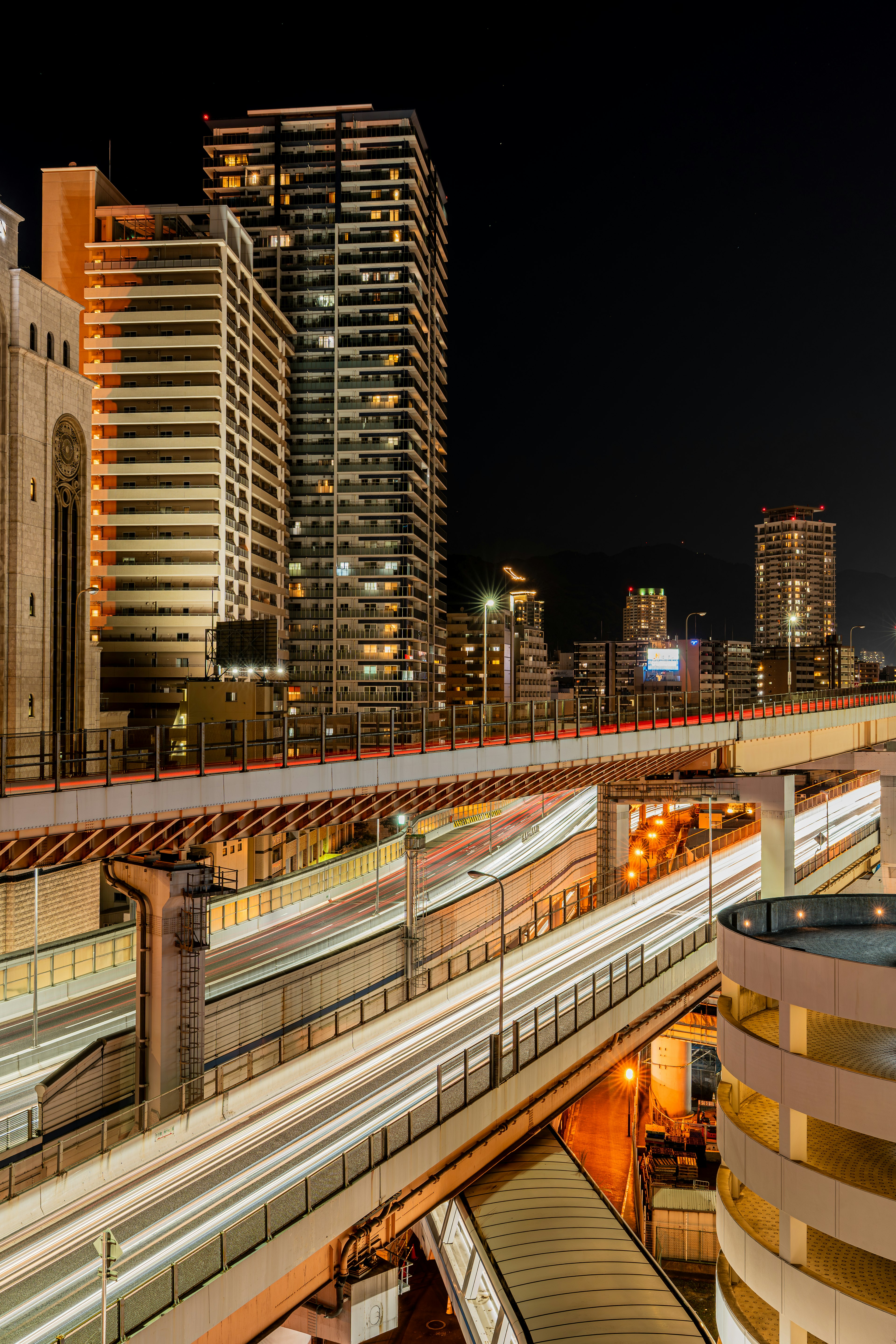 Paesaggio urbano notturno con grattacieli e ferrovie incrociate