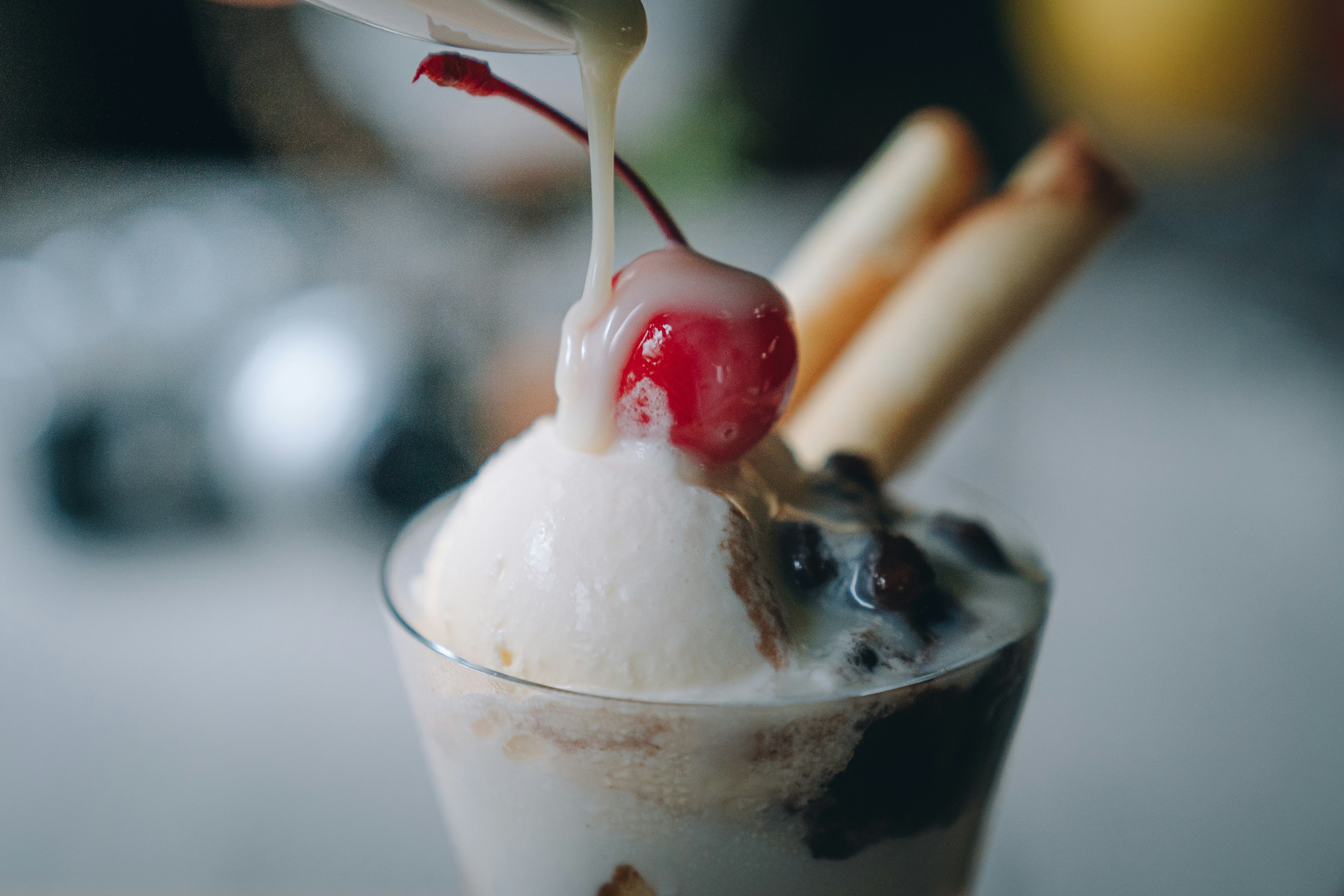 Nahaufnahme eines Desserts mit Eiscreme und einer Kirsche obendrauf