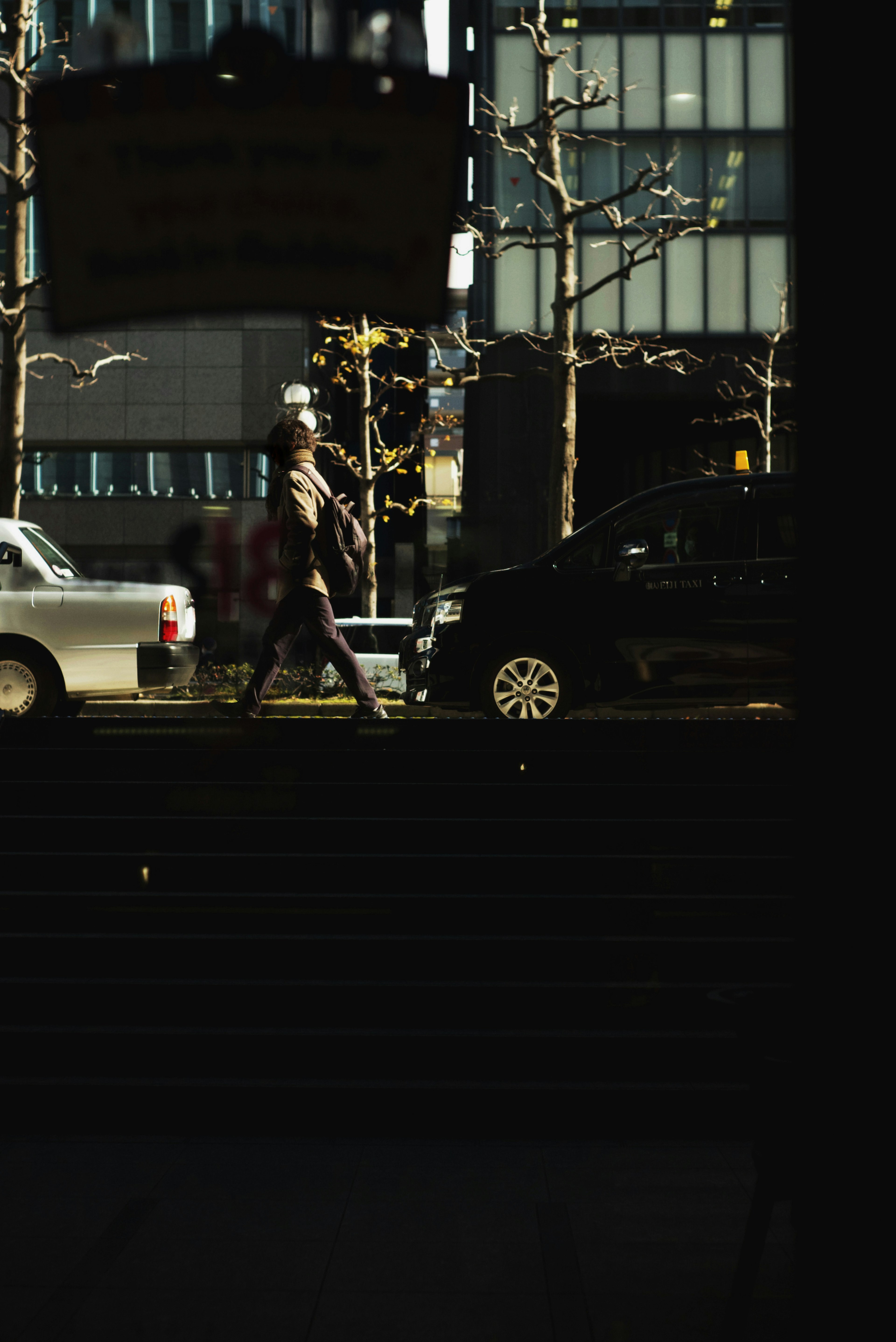 A person walking alongside cars in an urban setting