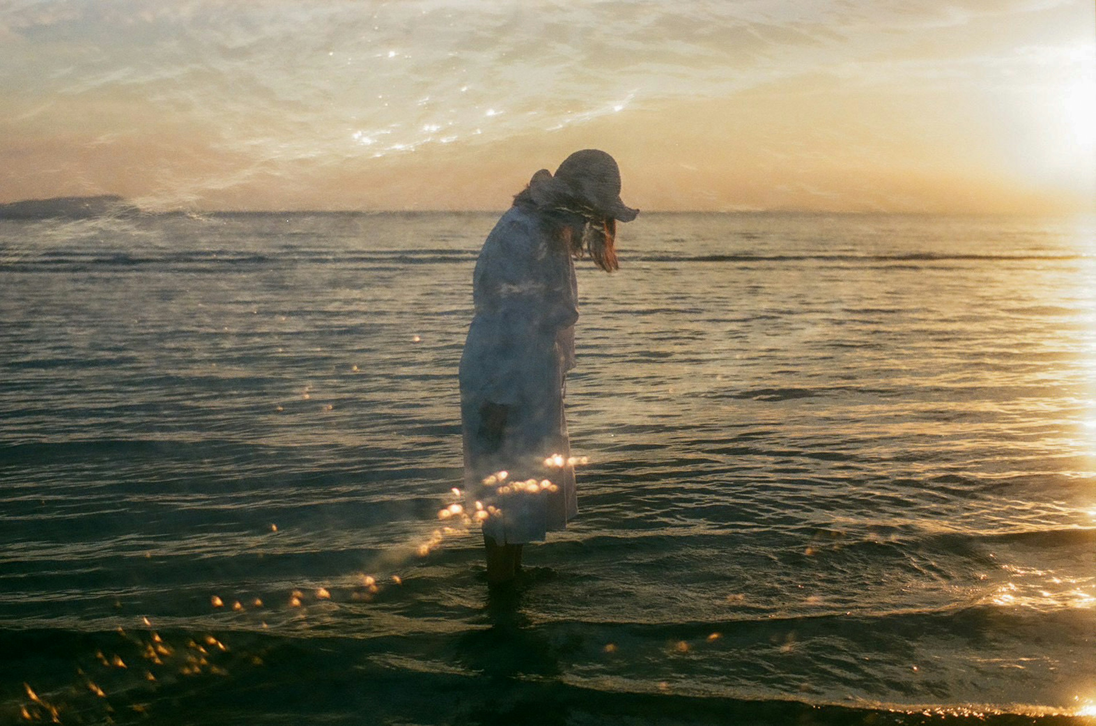 Silhouette d'une personne marchant dans la mer avec un beau coucher de soleil