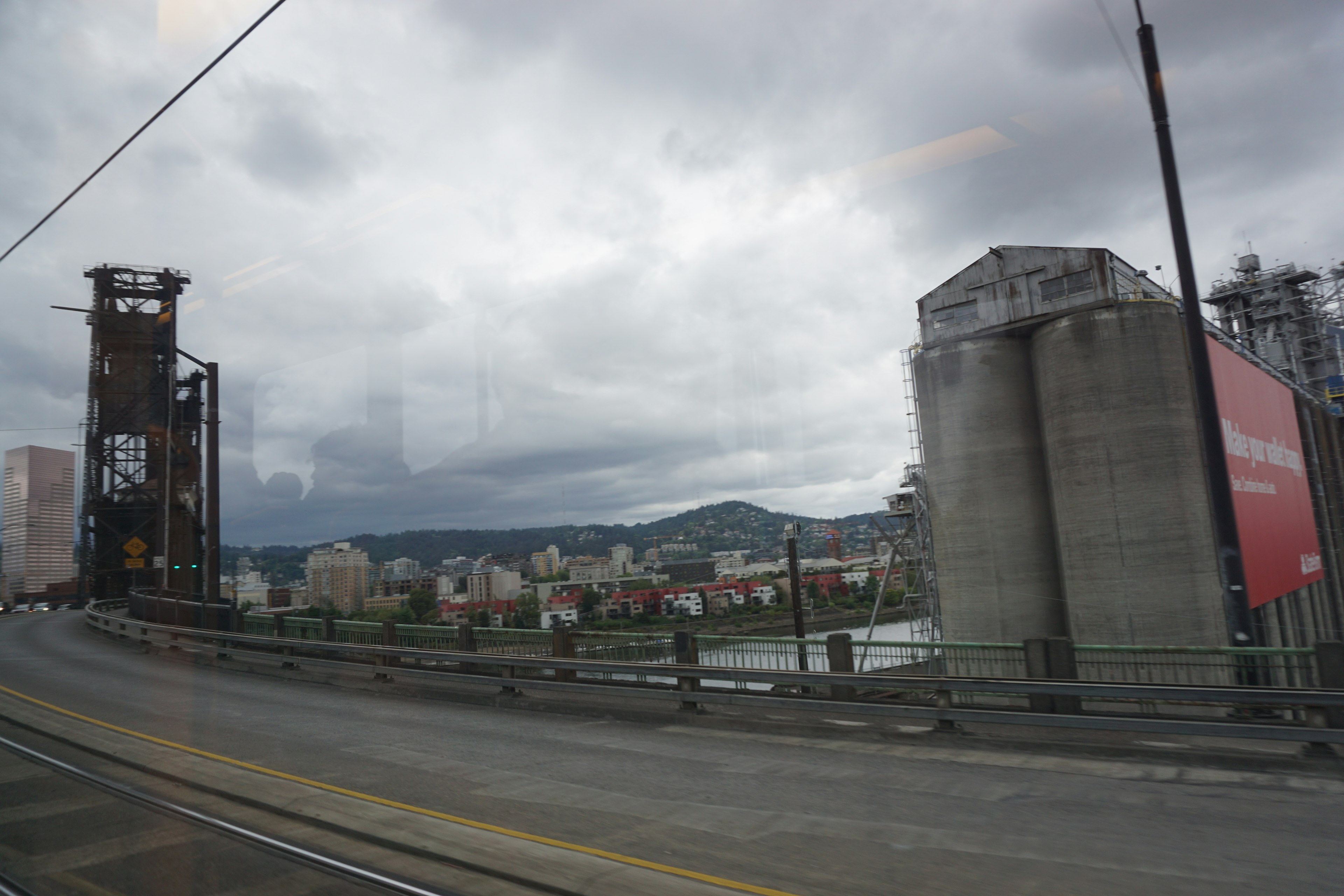 Industrial area with silos and bridge under cloudy sky