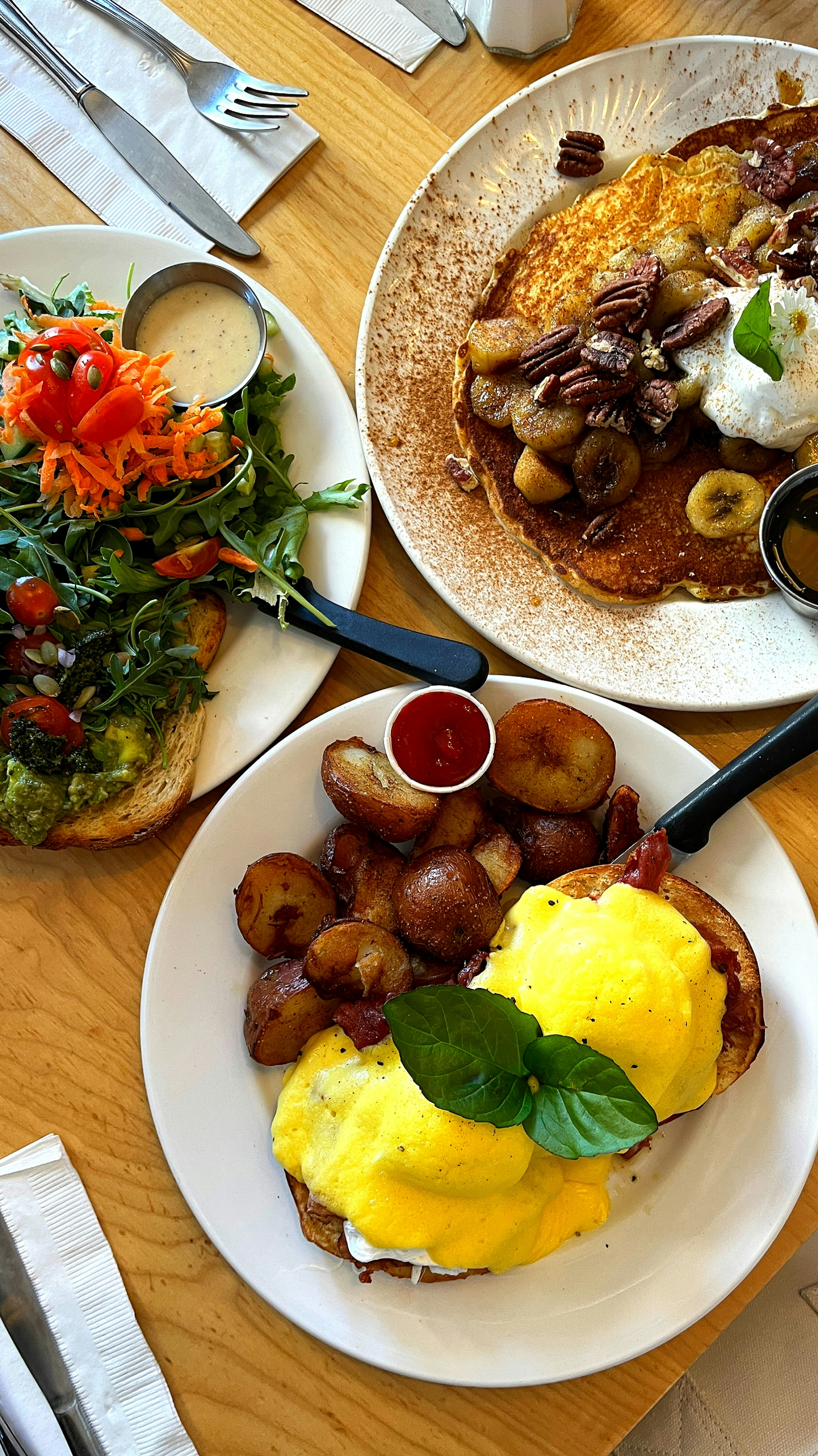 Piring sarapan berwarna-warni dengan Eggs Benedict, pancake, dan salad segar disusun dengan indah