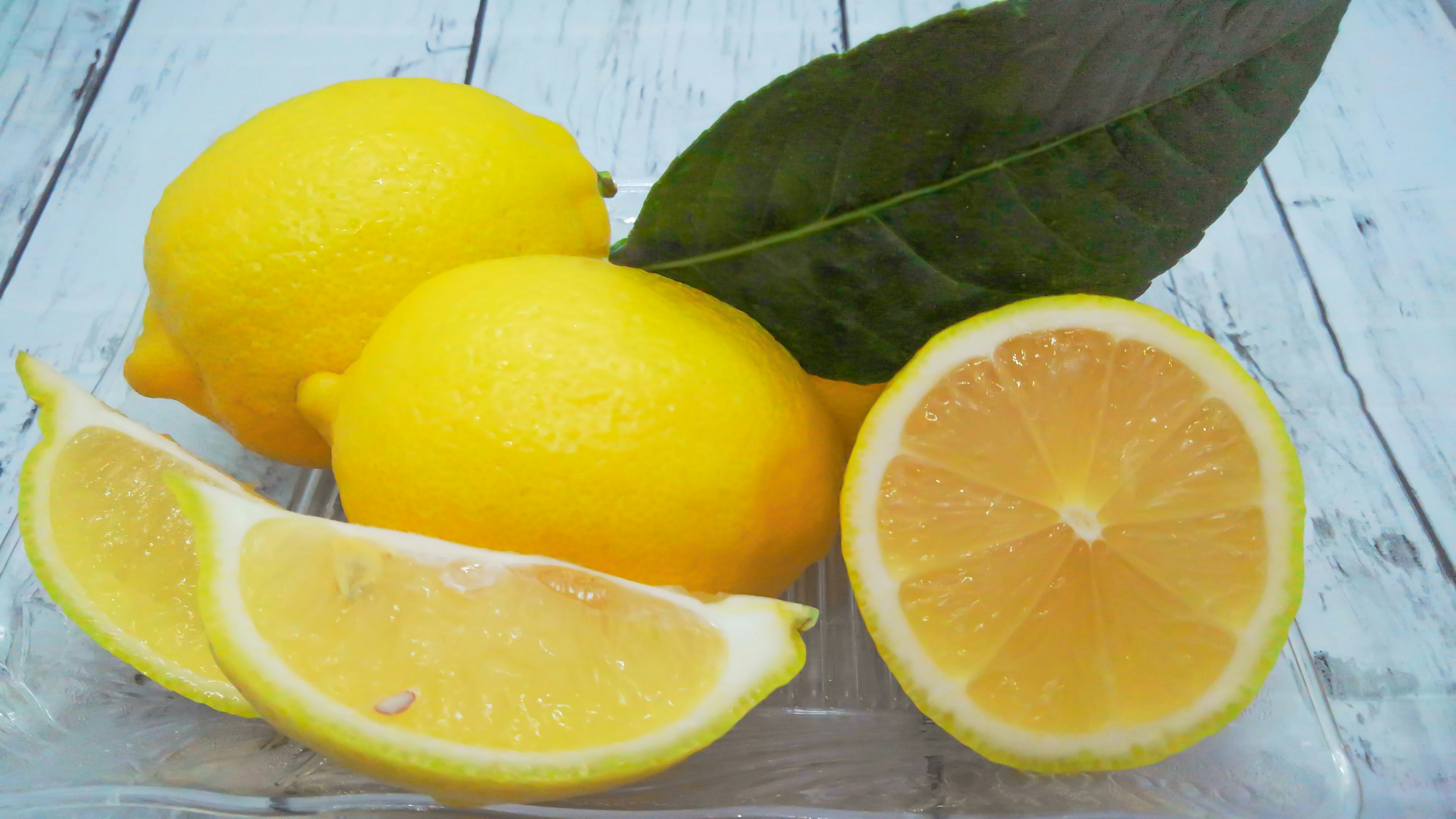 Citrons frais avec des feuilles vertes sur une table en bois