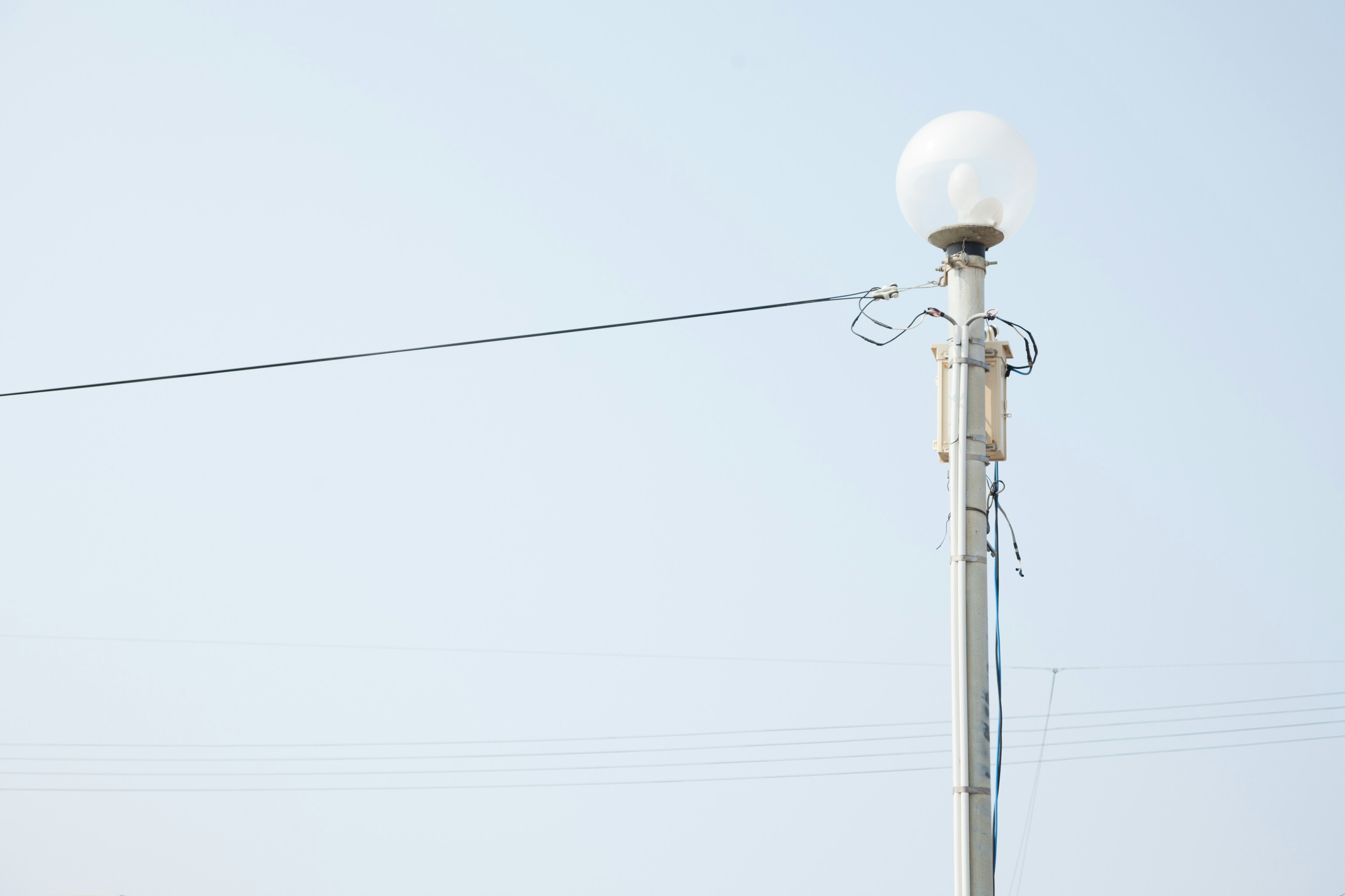 Tiang lampu jalan dengan cahaya bulat di bawah langit cerah