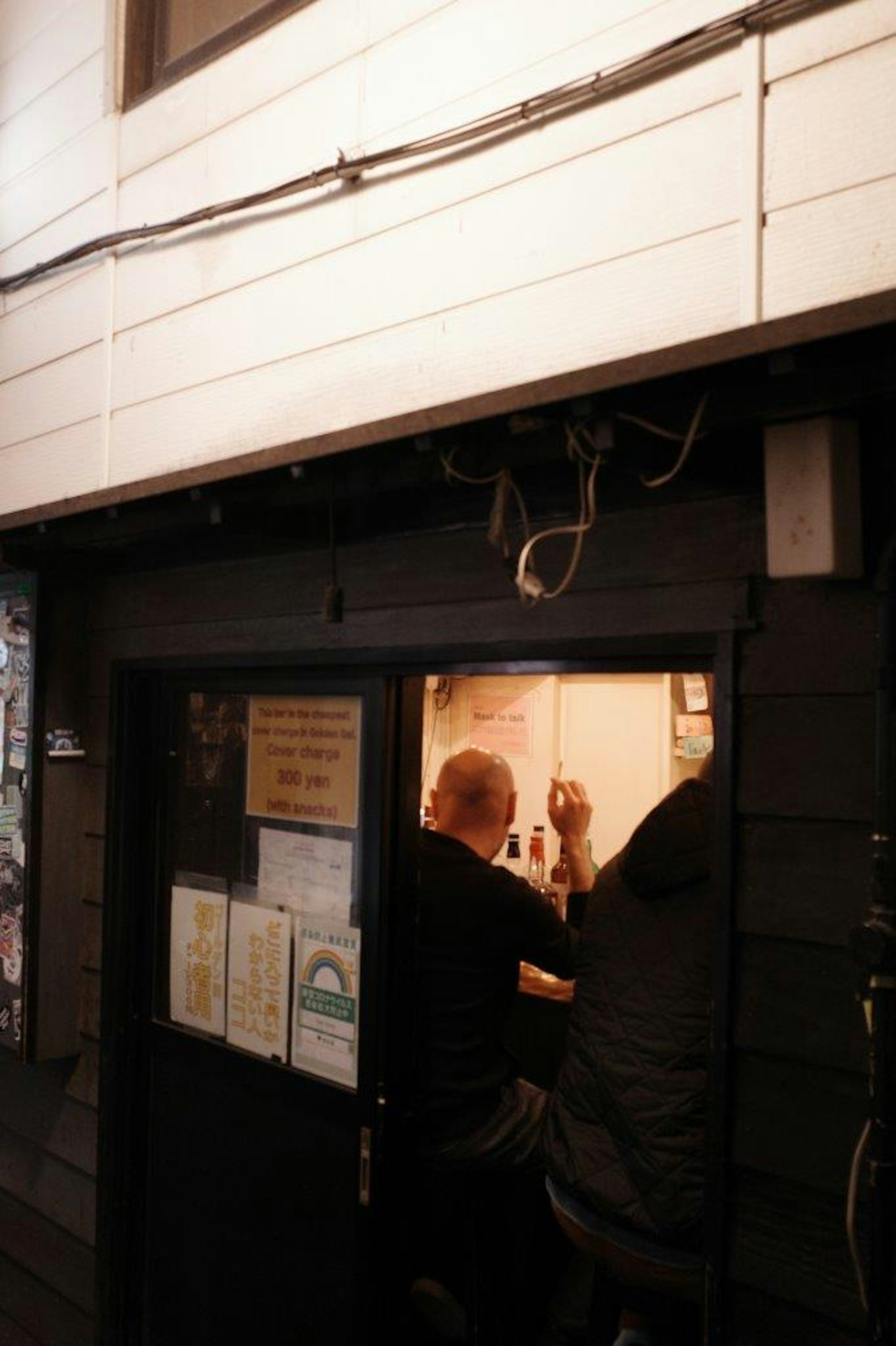 Dos personas sentadas en un mostrador en una tienda poco iluminada