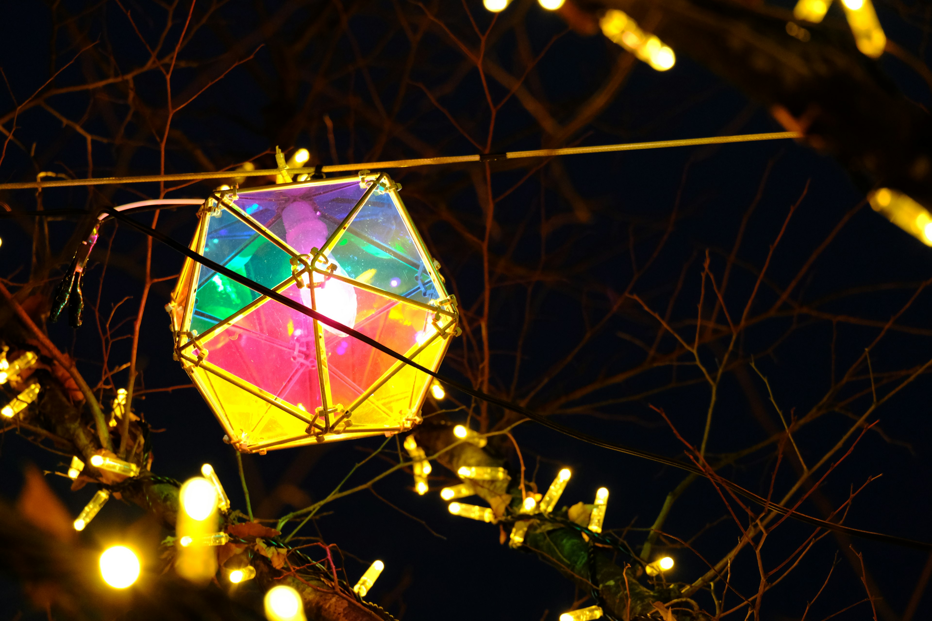 Colorful lantern hanging in the night with warm glowing lights