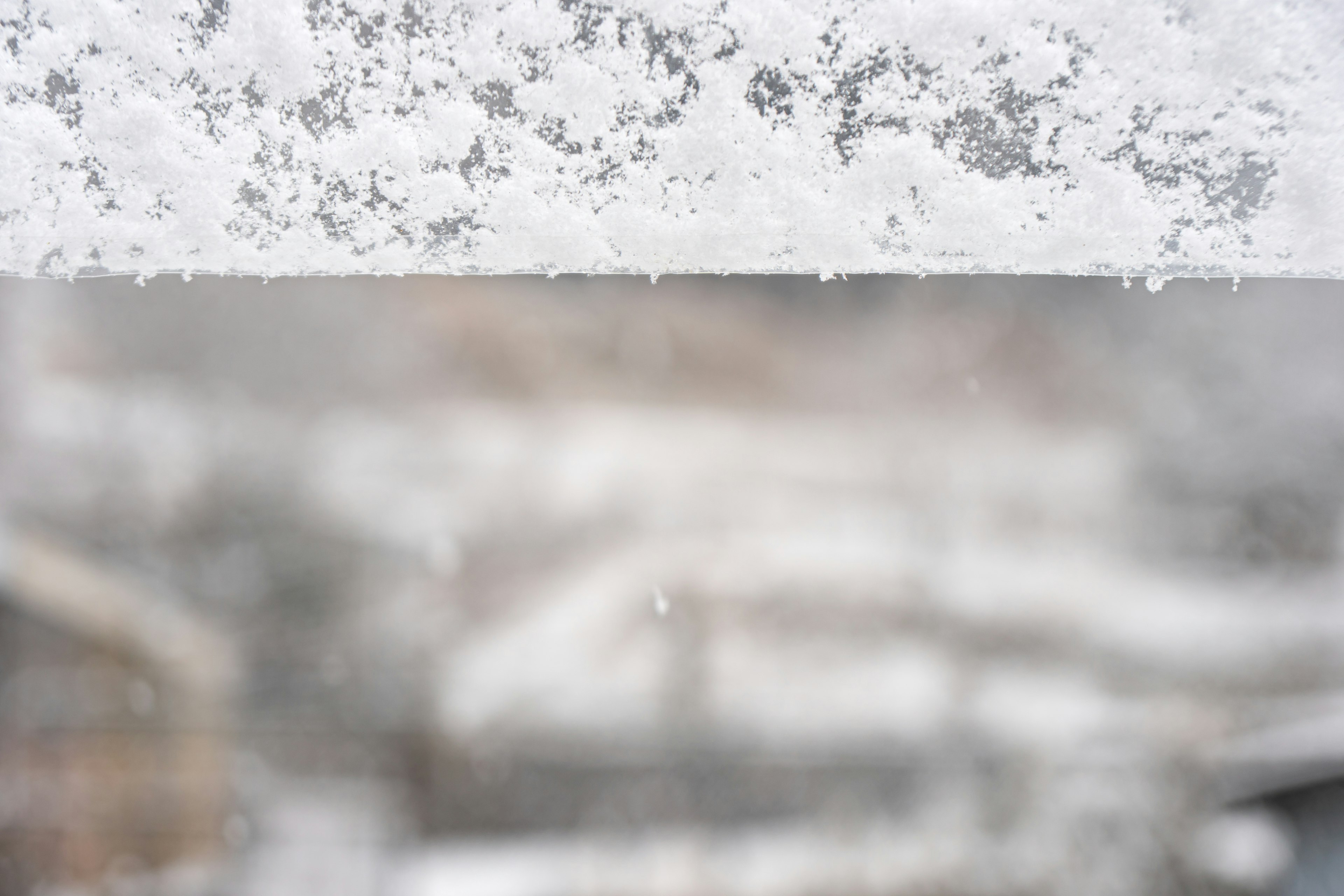 雪が降る窓越しの景色とぼやけた背景