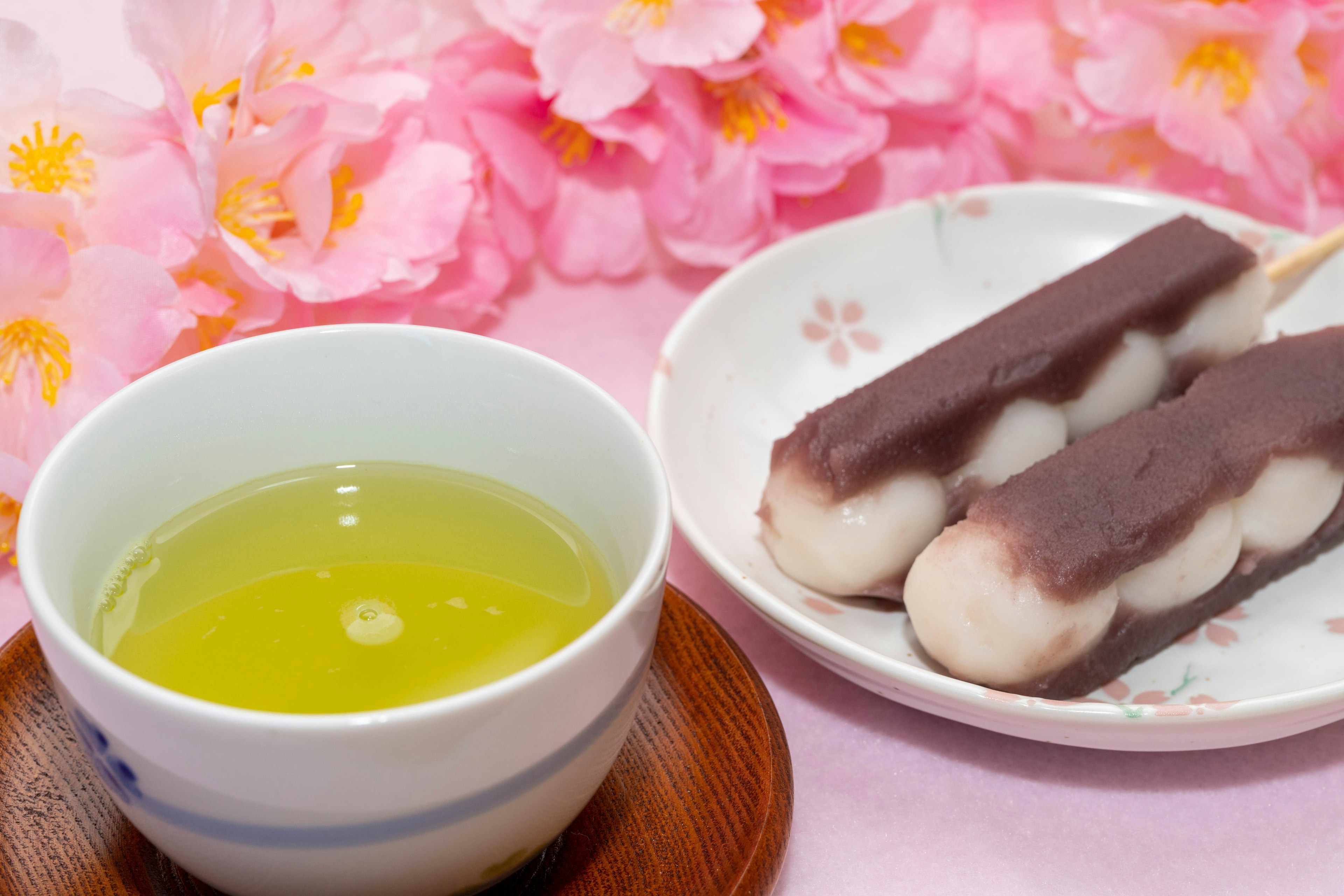 Tè verde e dessert di dango con uno sfondo di fiori di ciliegio