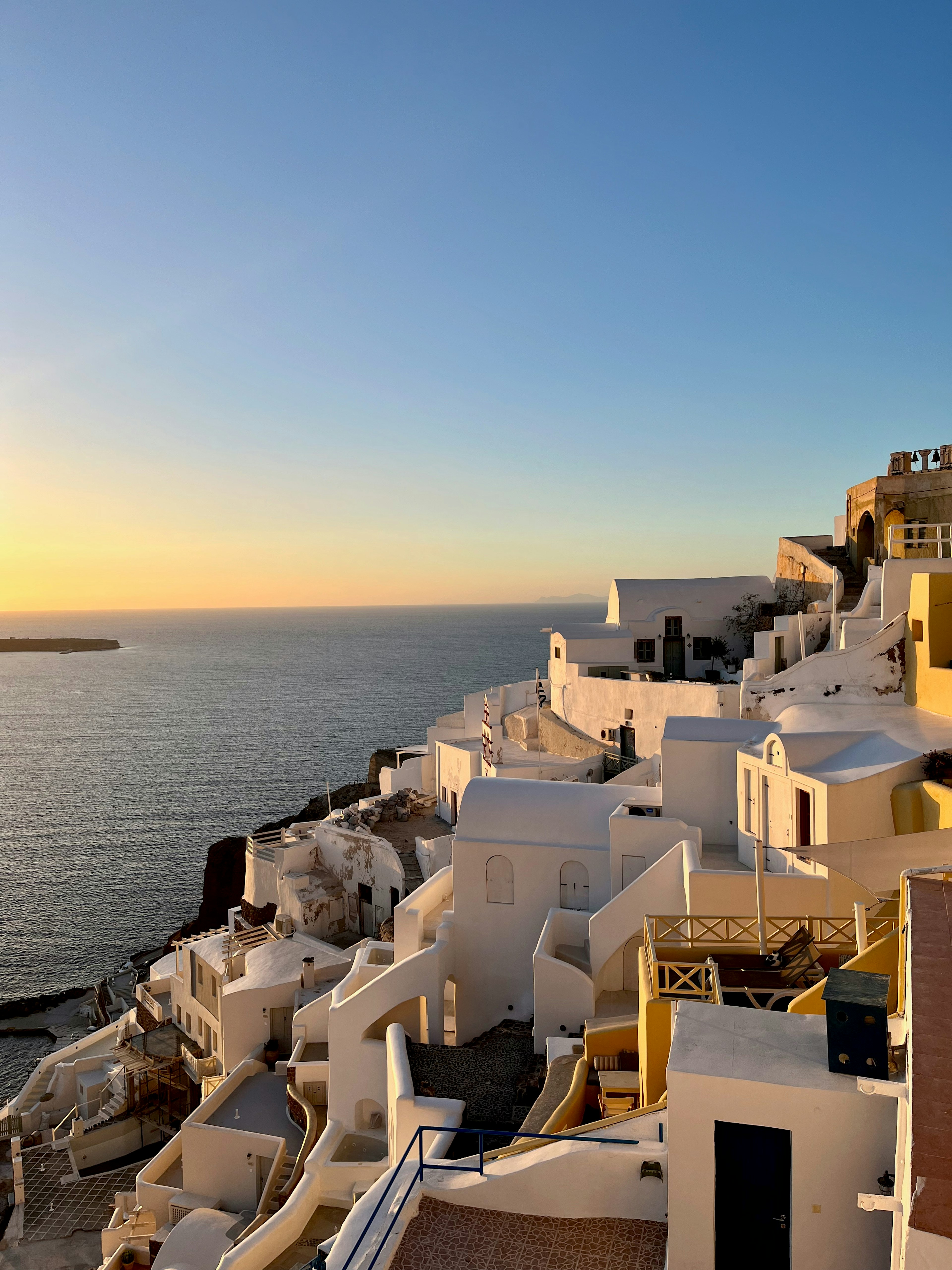 Bâtiments blancs de Santorin au coucher du soleil sur la mer bleue