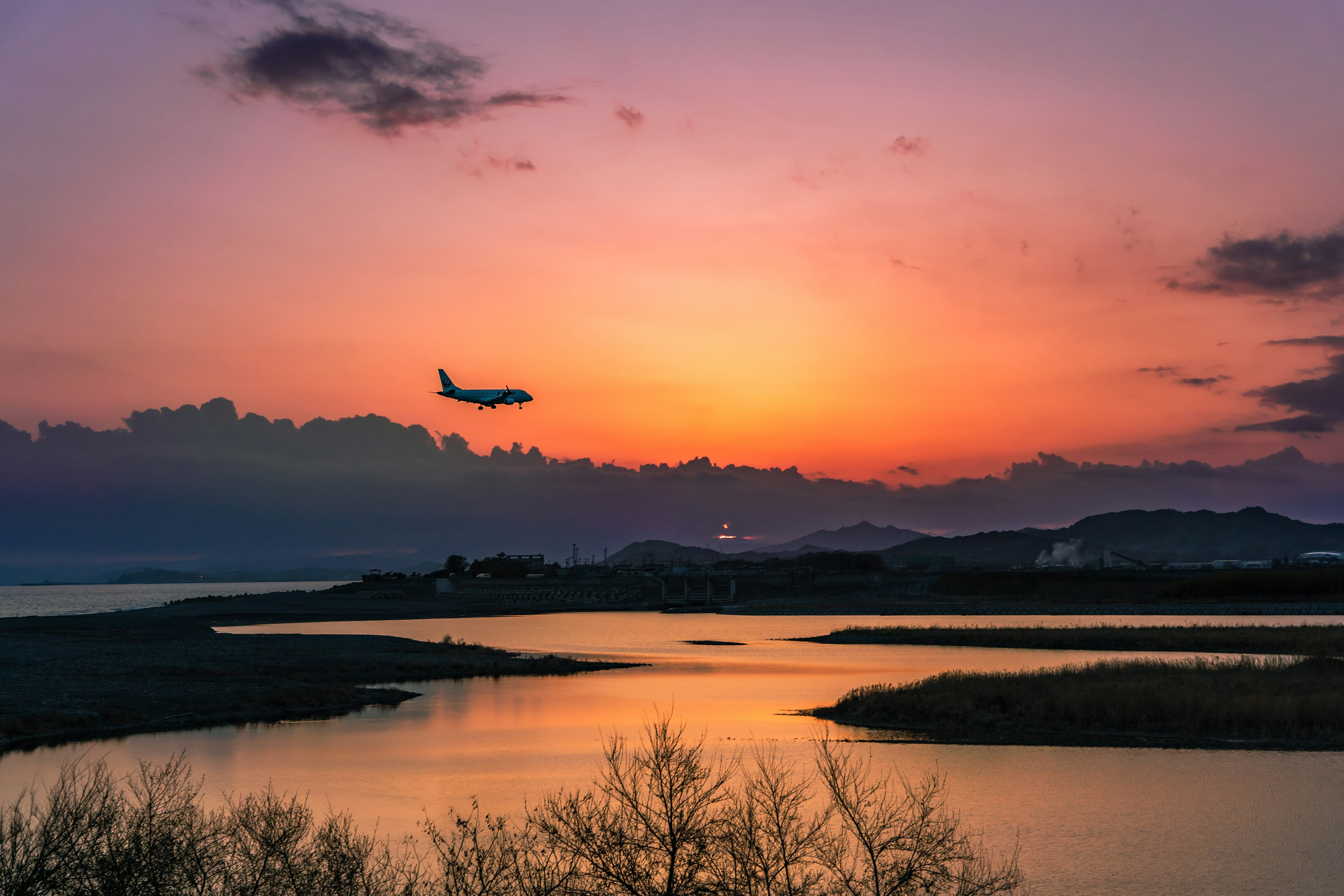 夕焼け空に飛行機が飛ぶ美しい風景