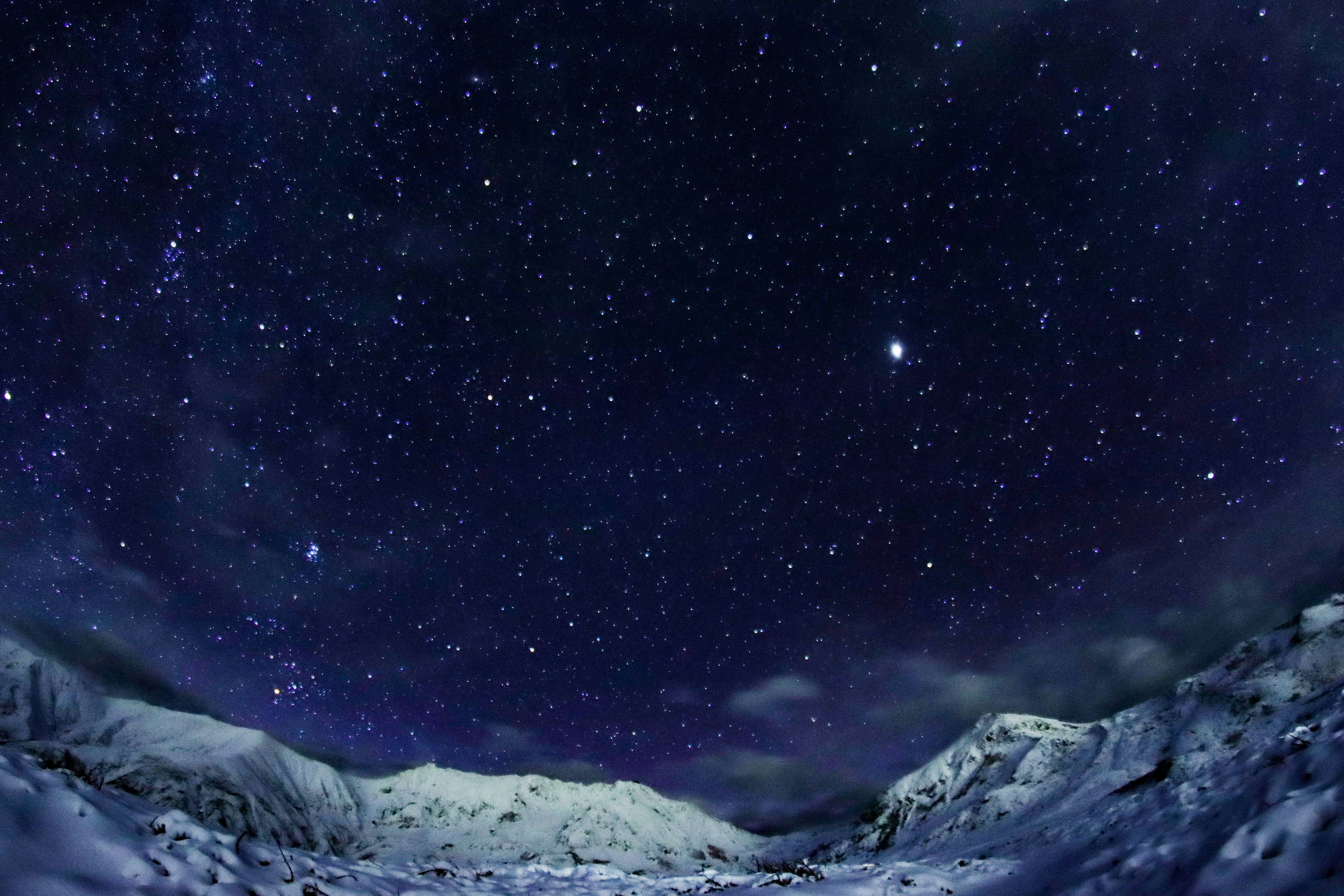 Beautiful landscape of snow-covered mountains under a starry sky