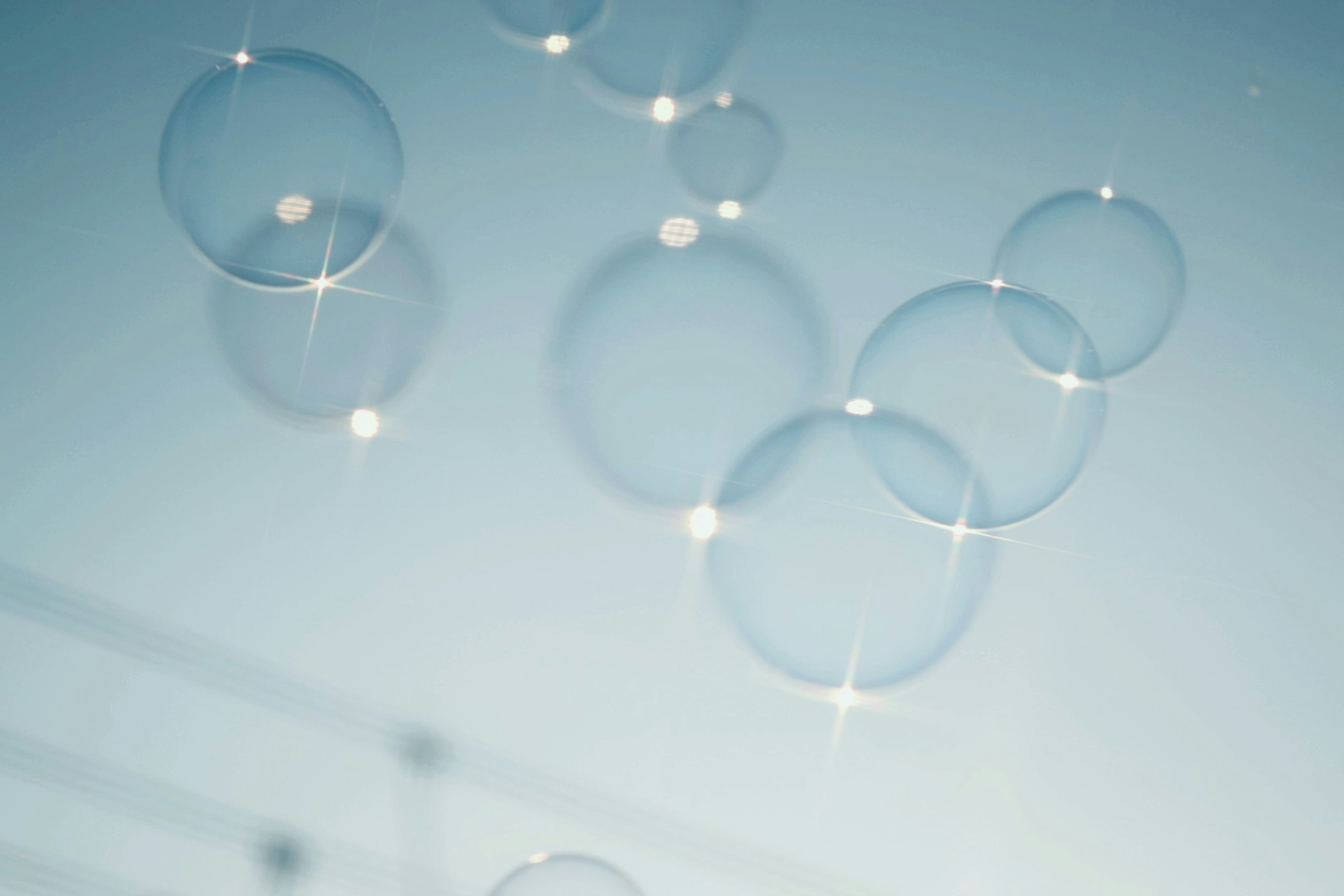 Cluster of transparent soap bubbles floating in a blue sky