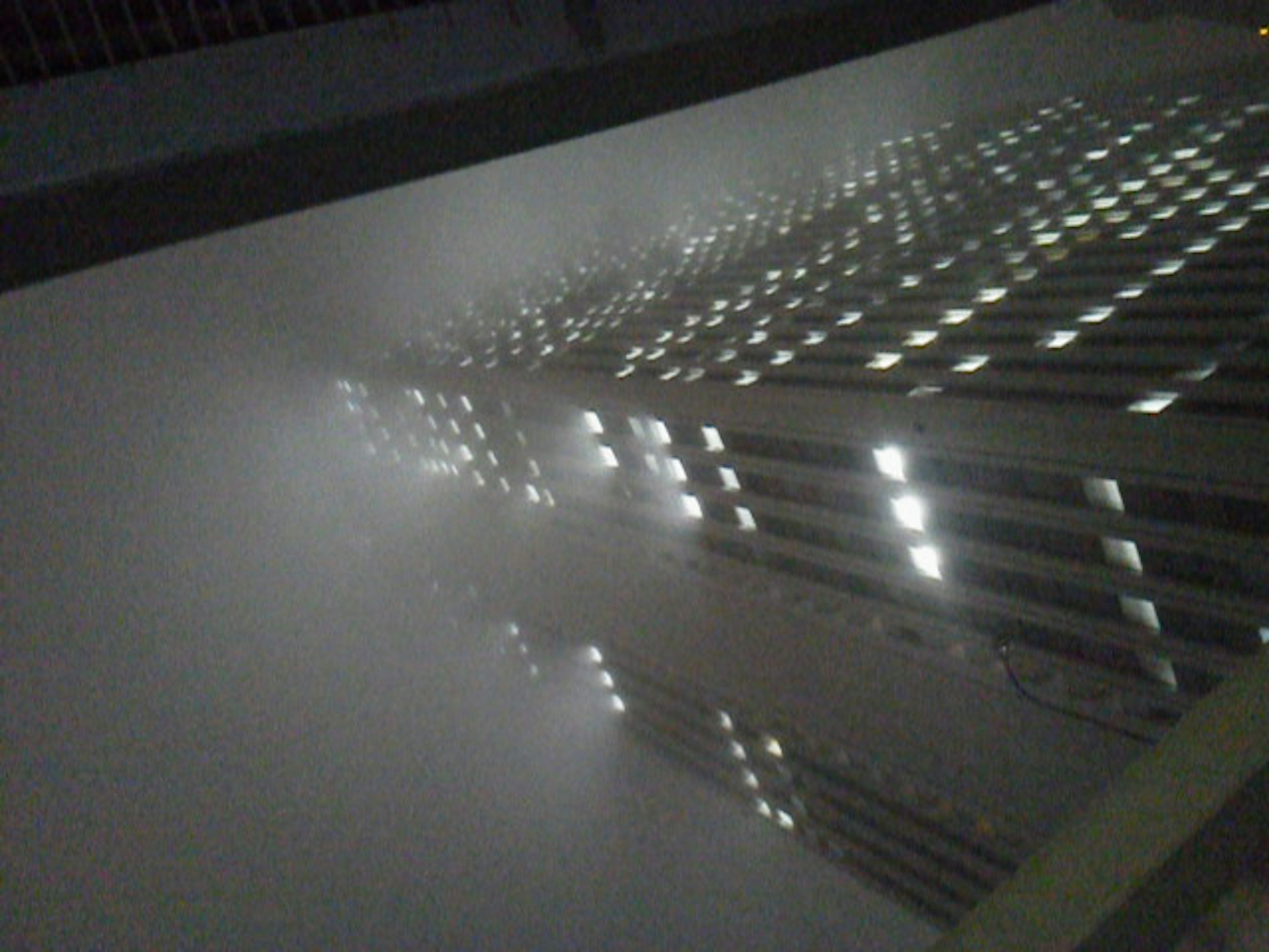 Reflejo de un edificio en la niebla con ventanas iluminadas