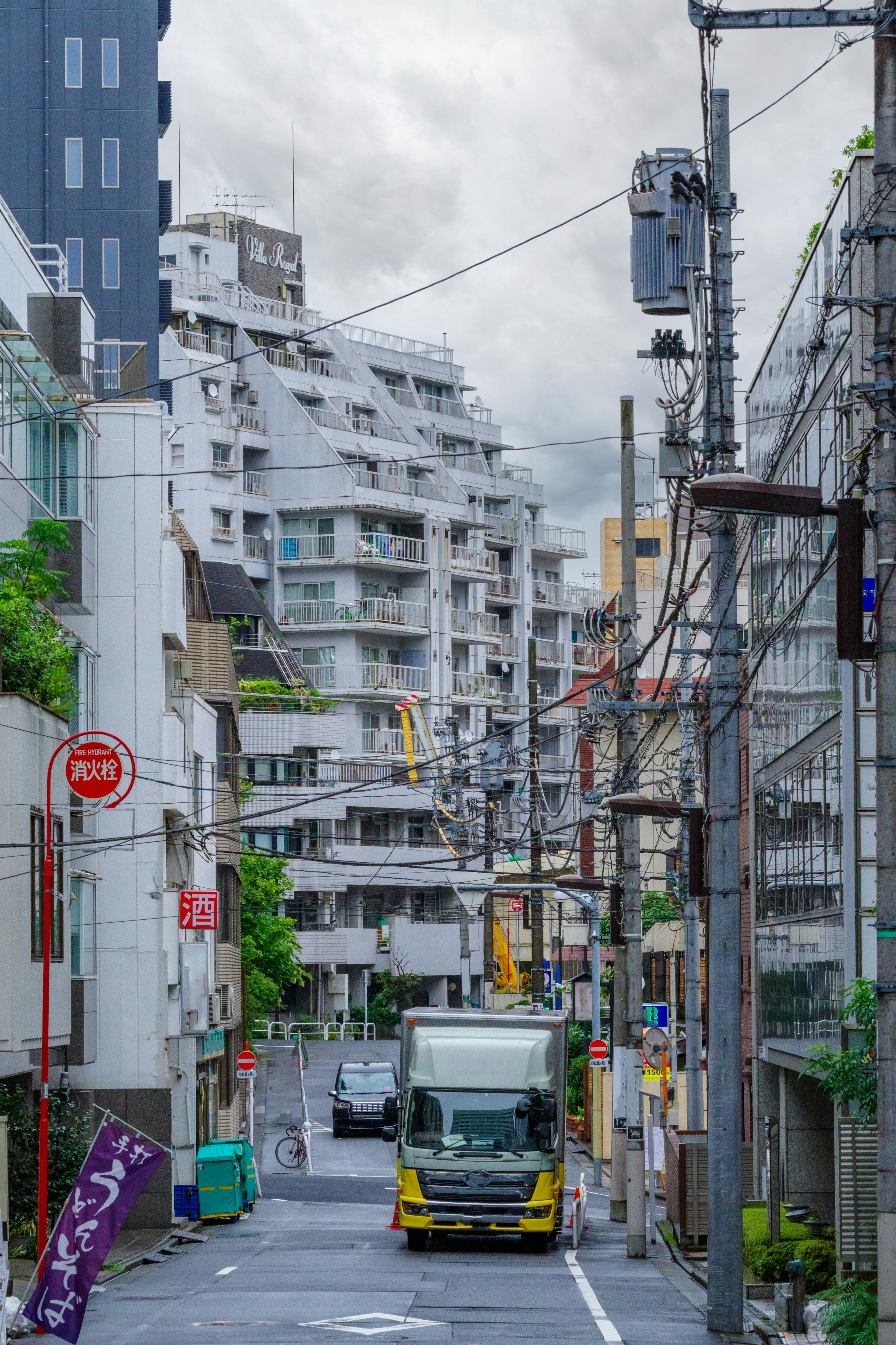 都市の通りにトラックが走る風景 ビルが並ぶ街並み 曇り空