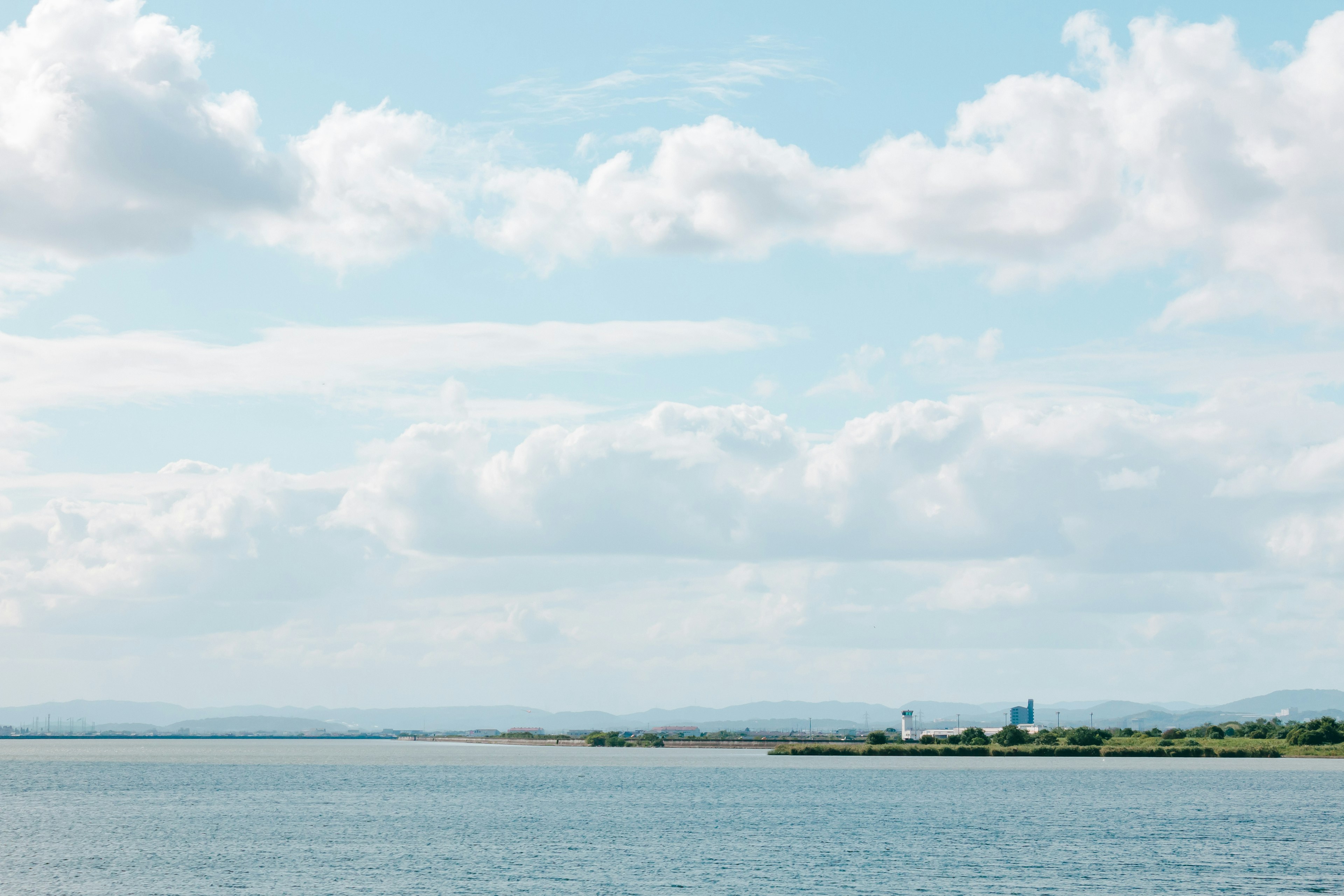 Calm sea and blue sky with distant mountains visible