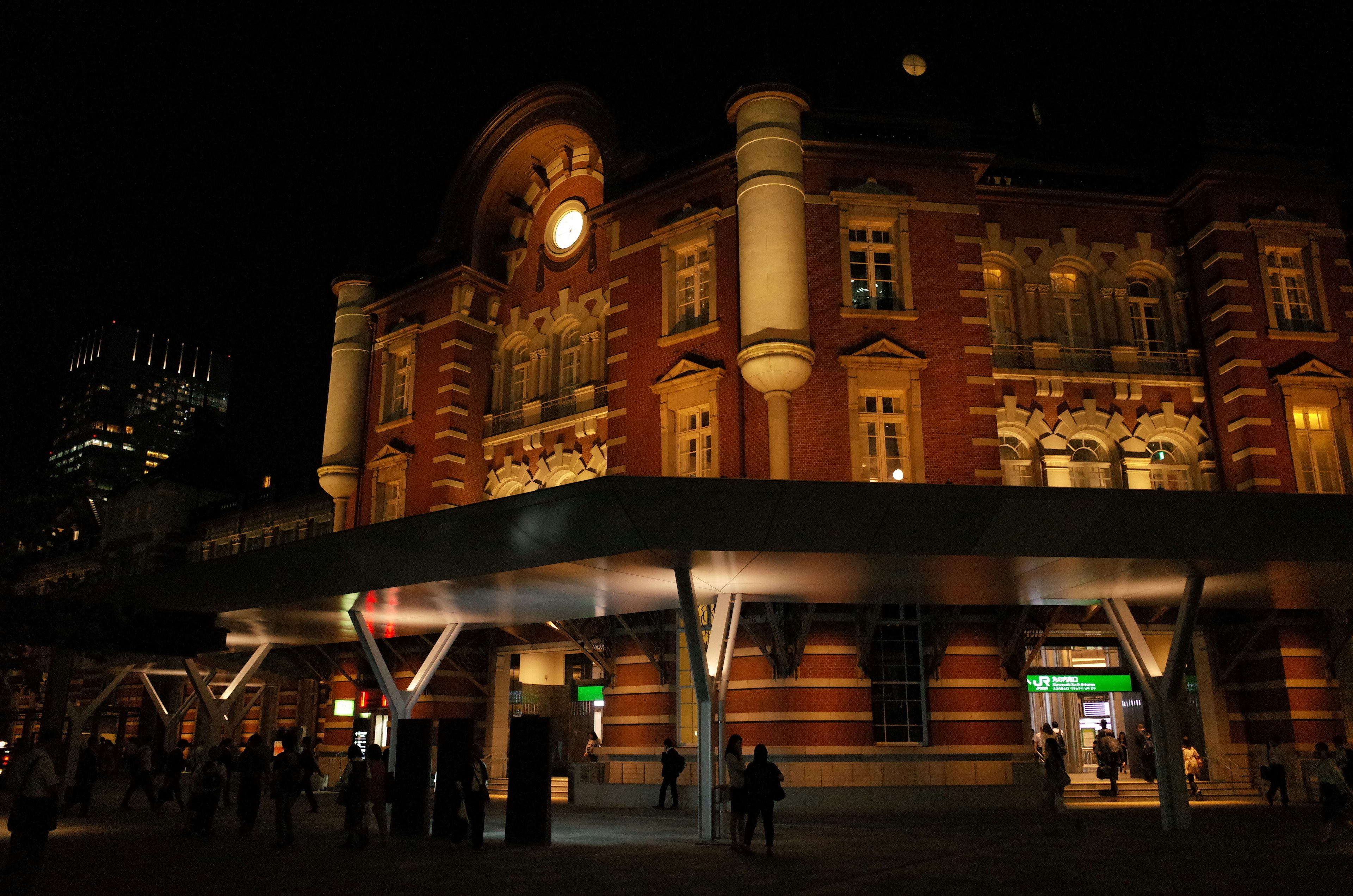 Tokyo Station at night featuring red brick architecture and clock