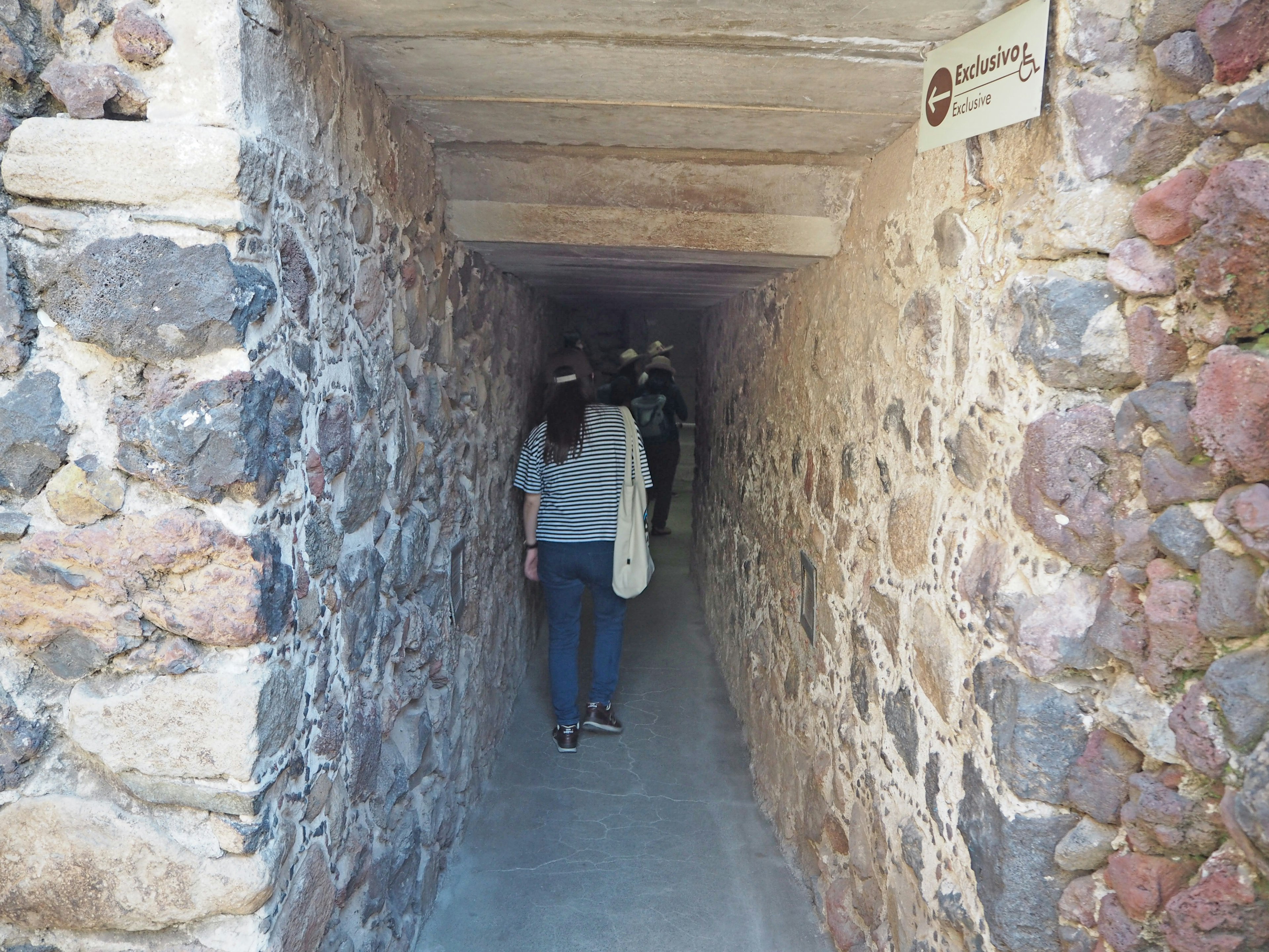 Narrow stone passage with a person walking through