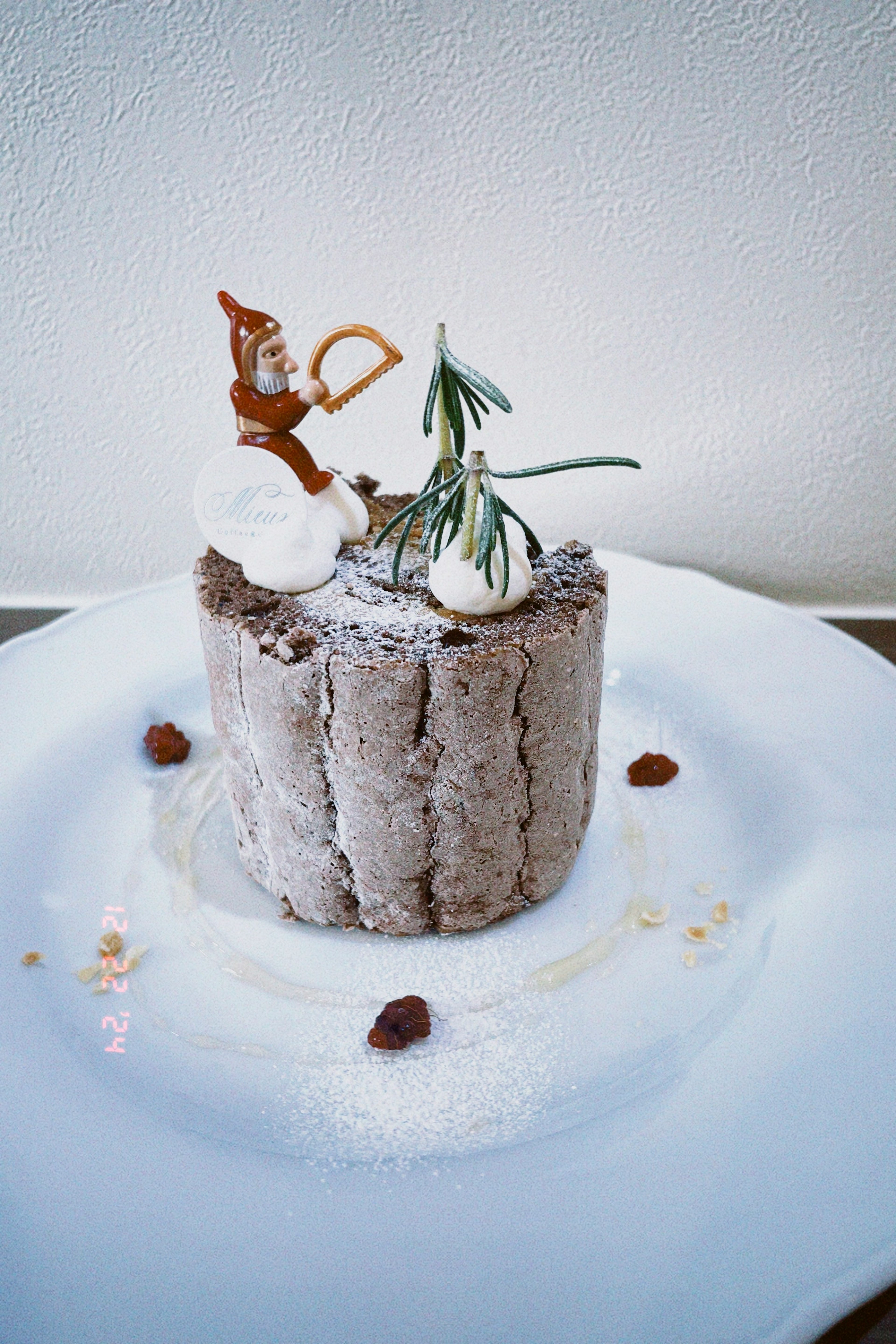 Pastel de chocolate con decoración nevada que presenta a un pequeño Santa Claus y un árbol de Navidad