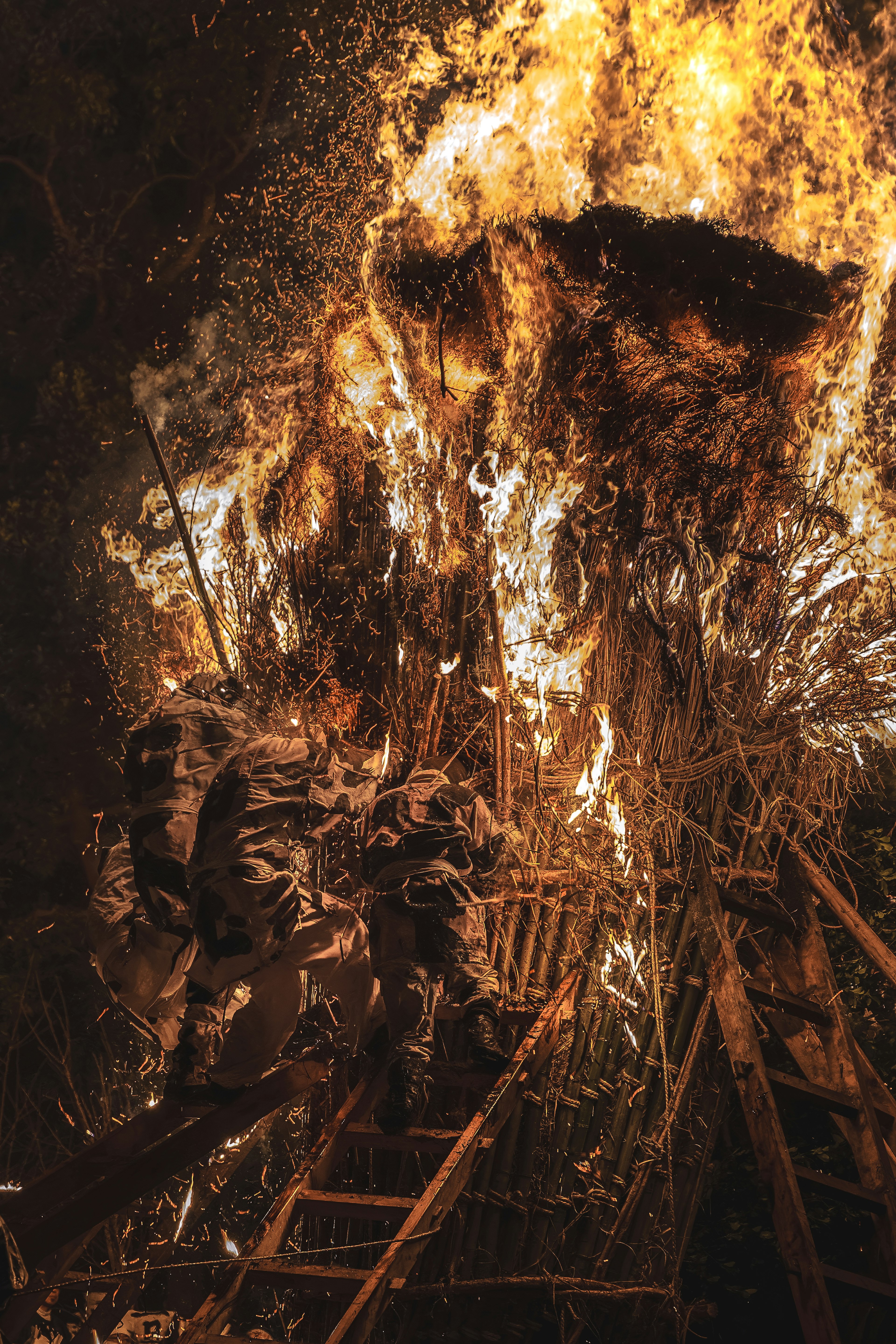 Detail of a structure made of wood and straw engulfed in flames