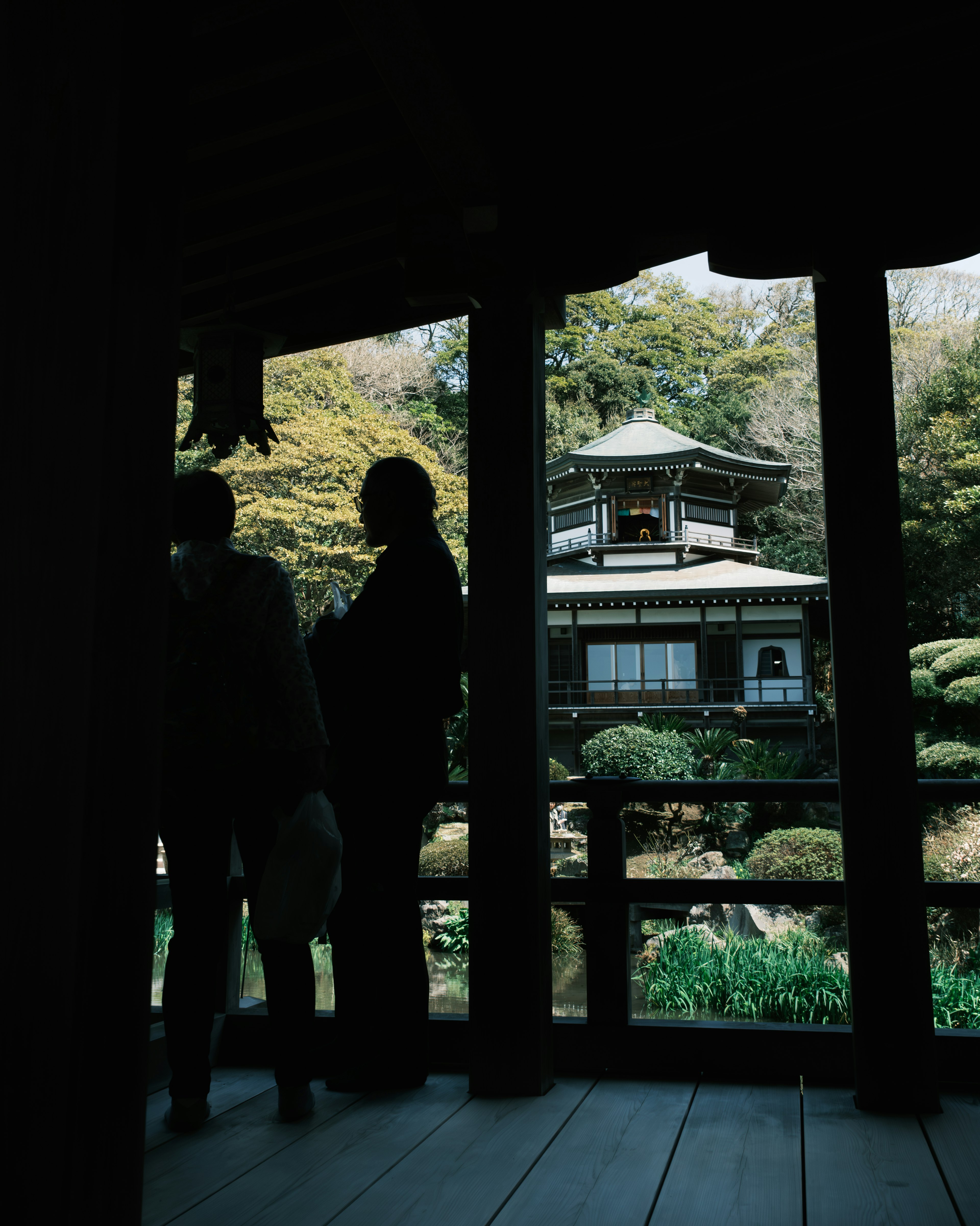 Silhouette de personnes dans un jardin japonais traditionnel avec une pagode en arrière-plan