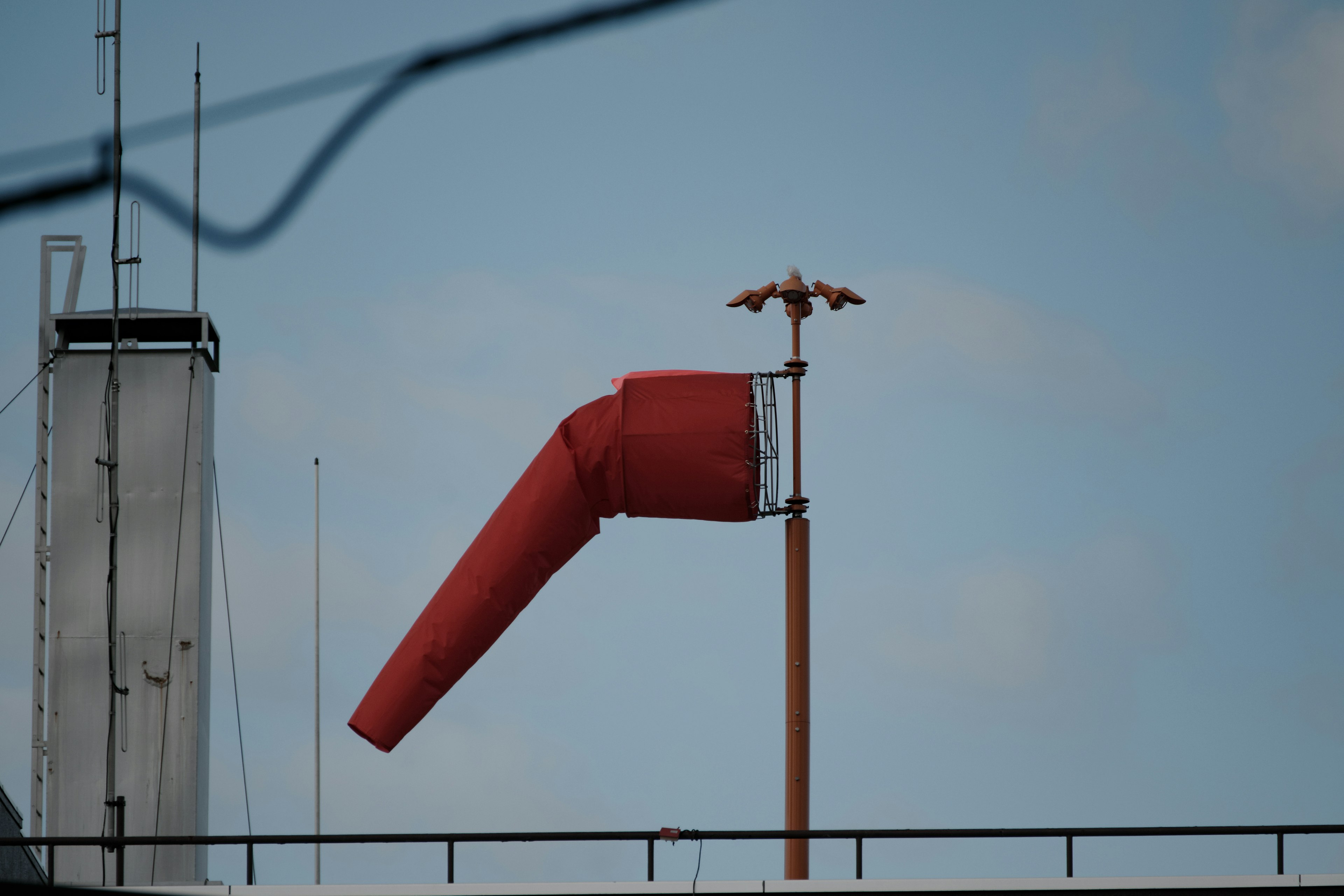 Red windsock standing against a blue sky