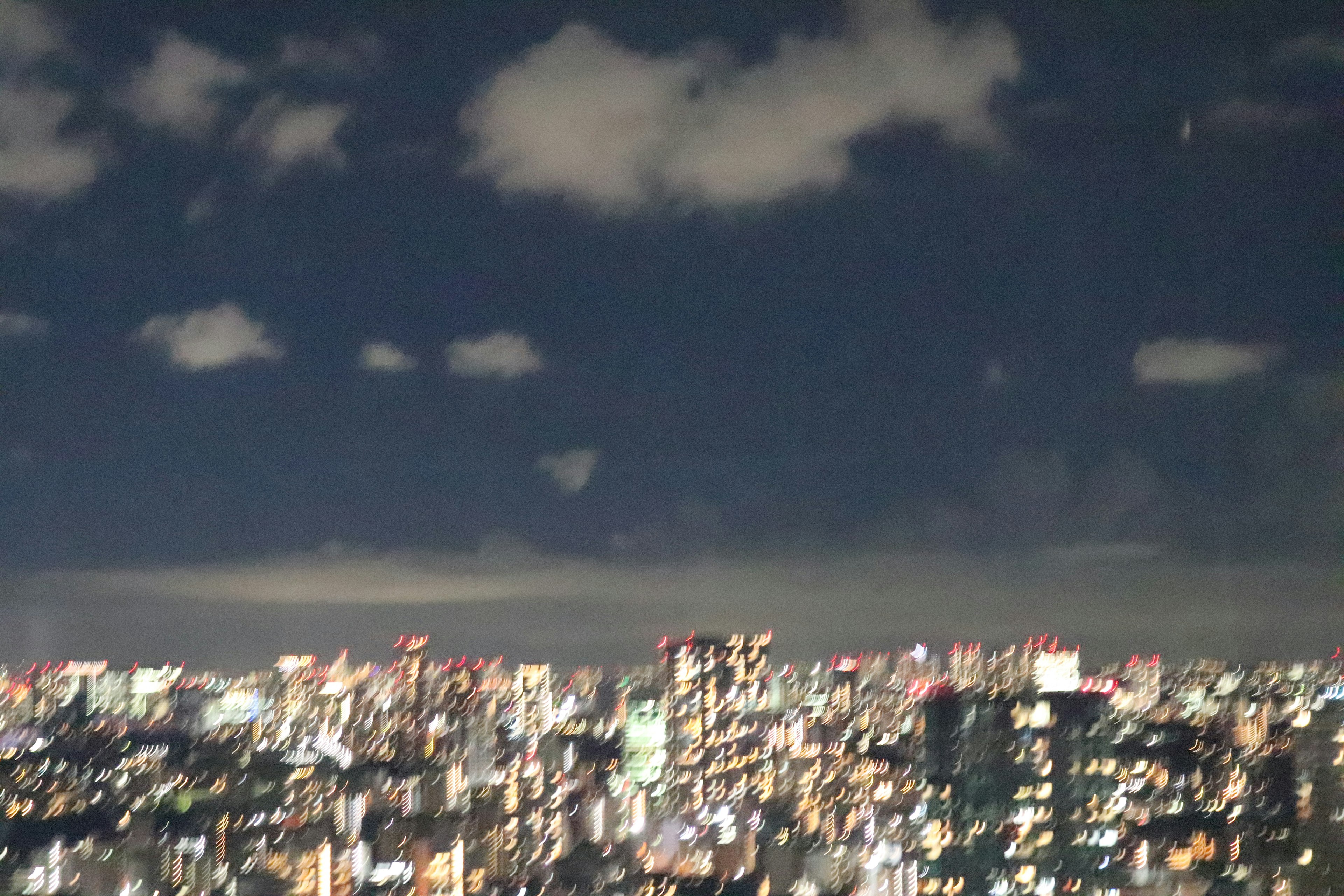 Paesaggio urbano notturno con grattacieli illuminati che mostrano lo skyline di Tokyo