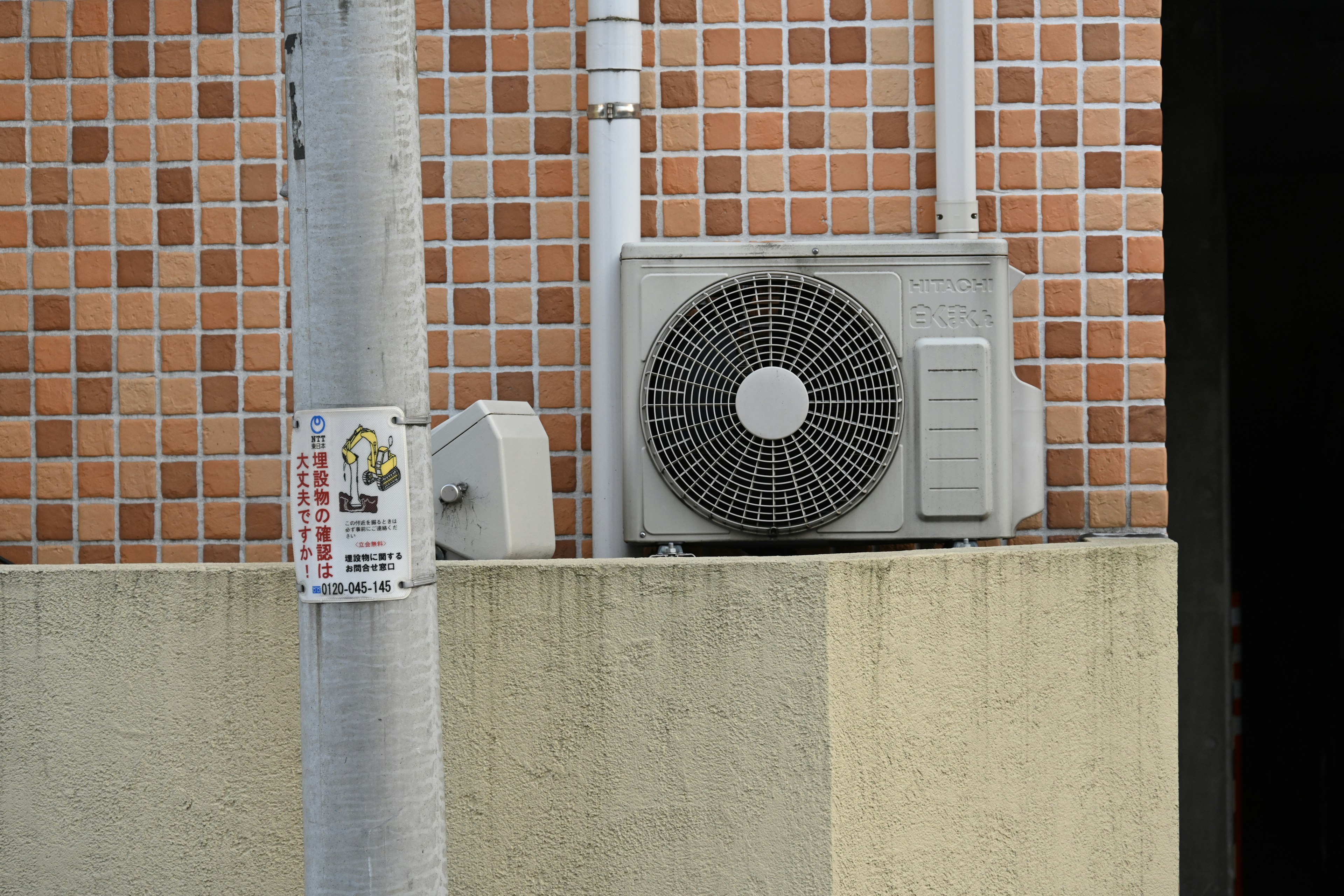 Air conditioning unit mounted on a building wall with tiled design